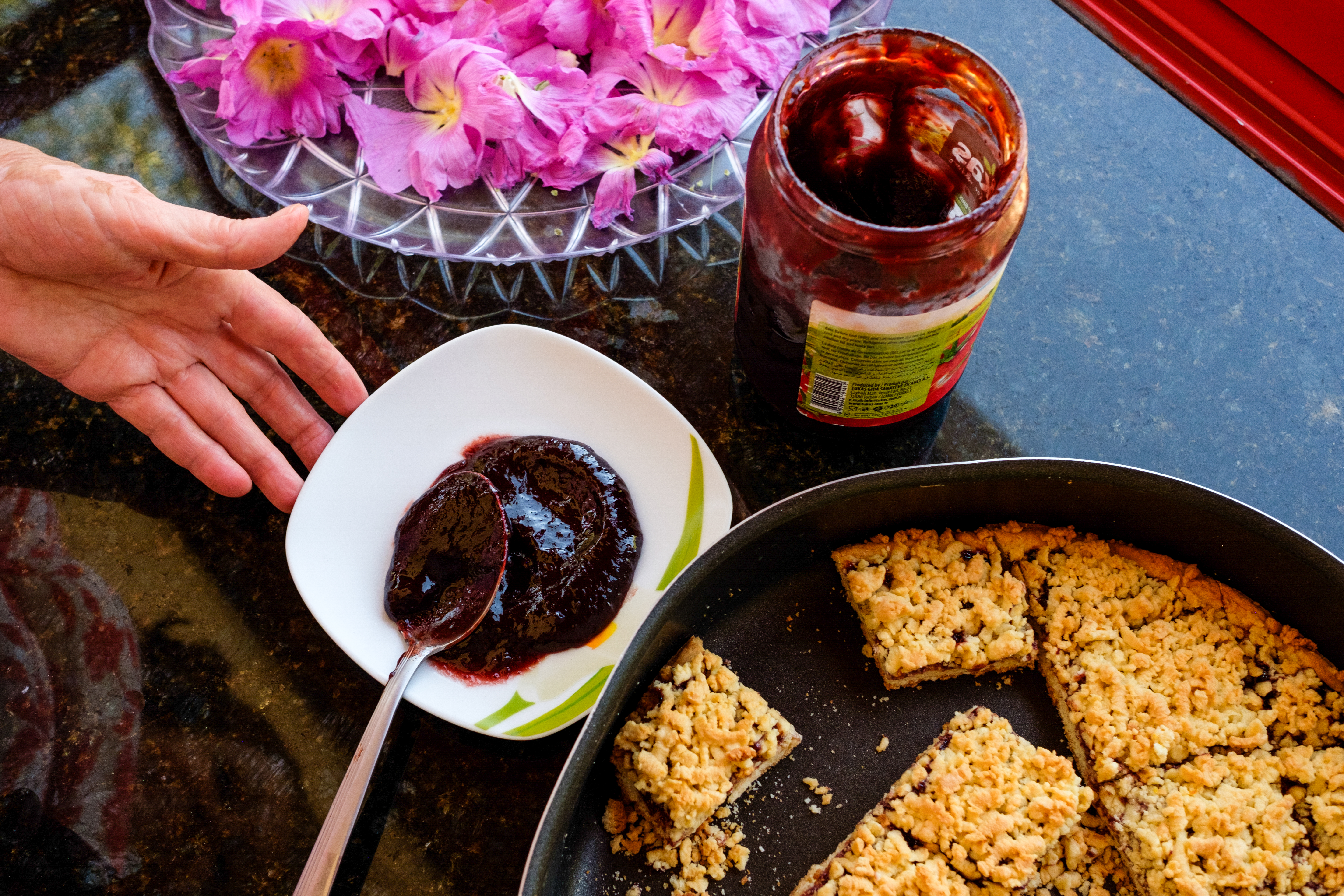 Pink flowers drying to be mixed with herbal tea, handmade plum jam, and baked dessert