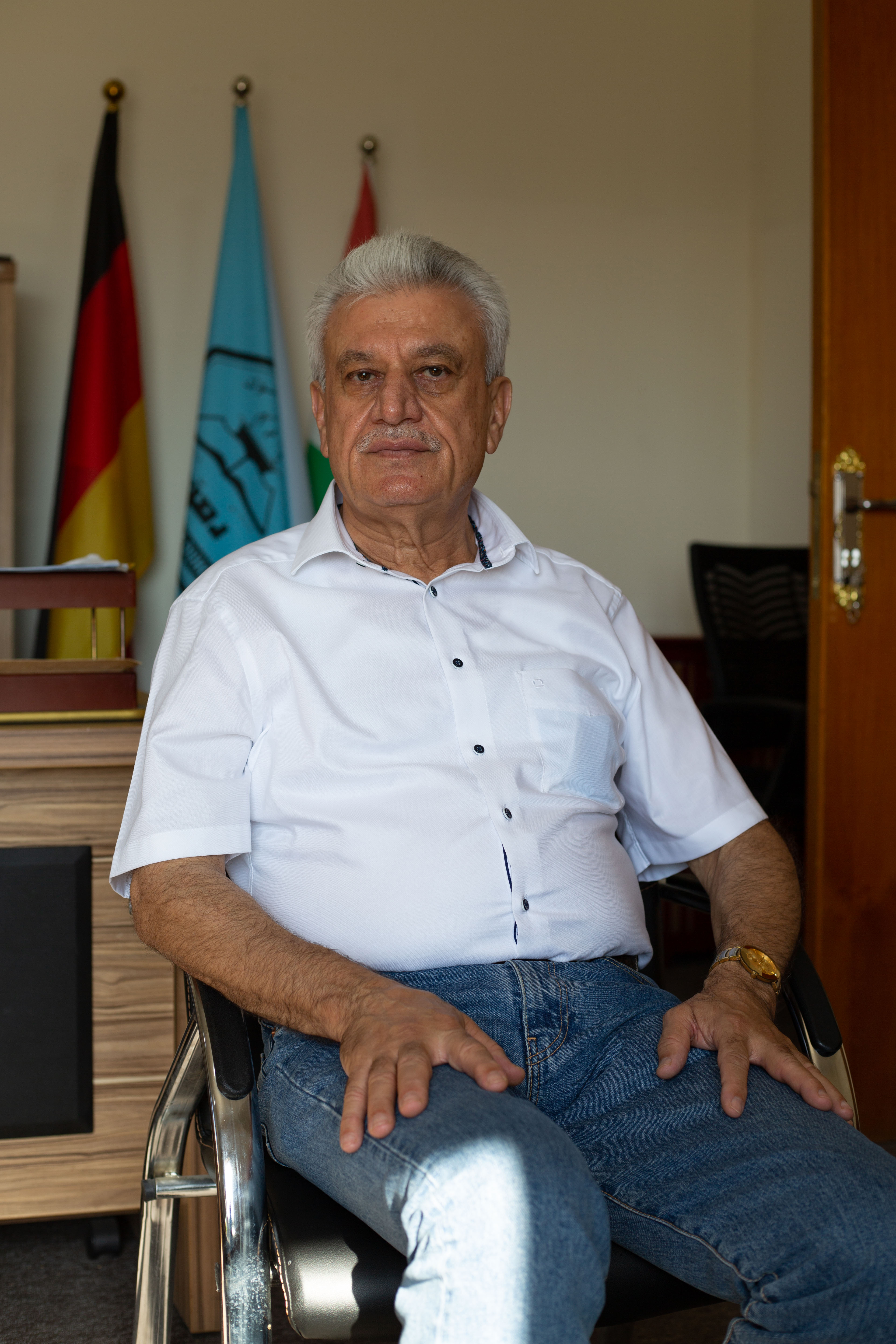 A photo of a man sitting and facing forward.