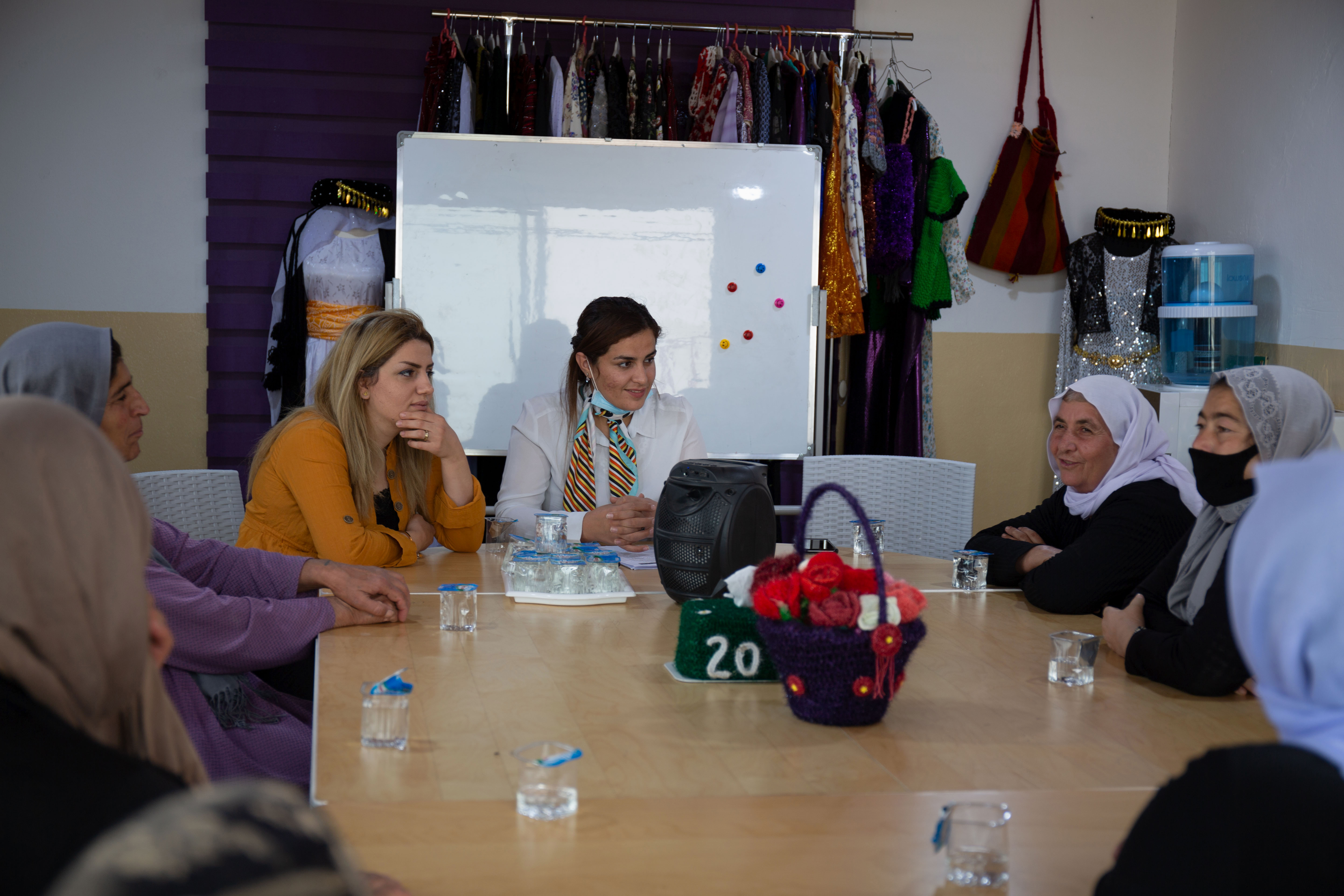 A photo of a group of women sitting around a table talking.