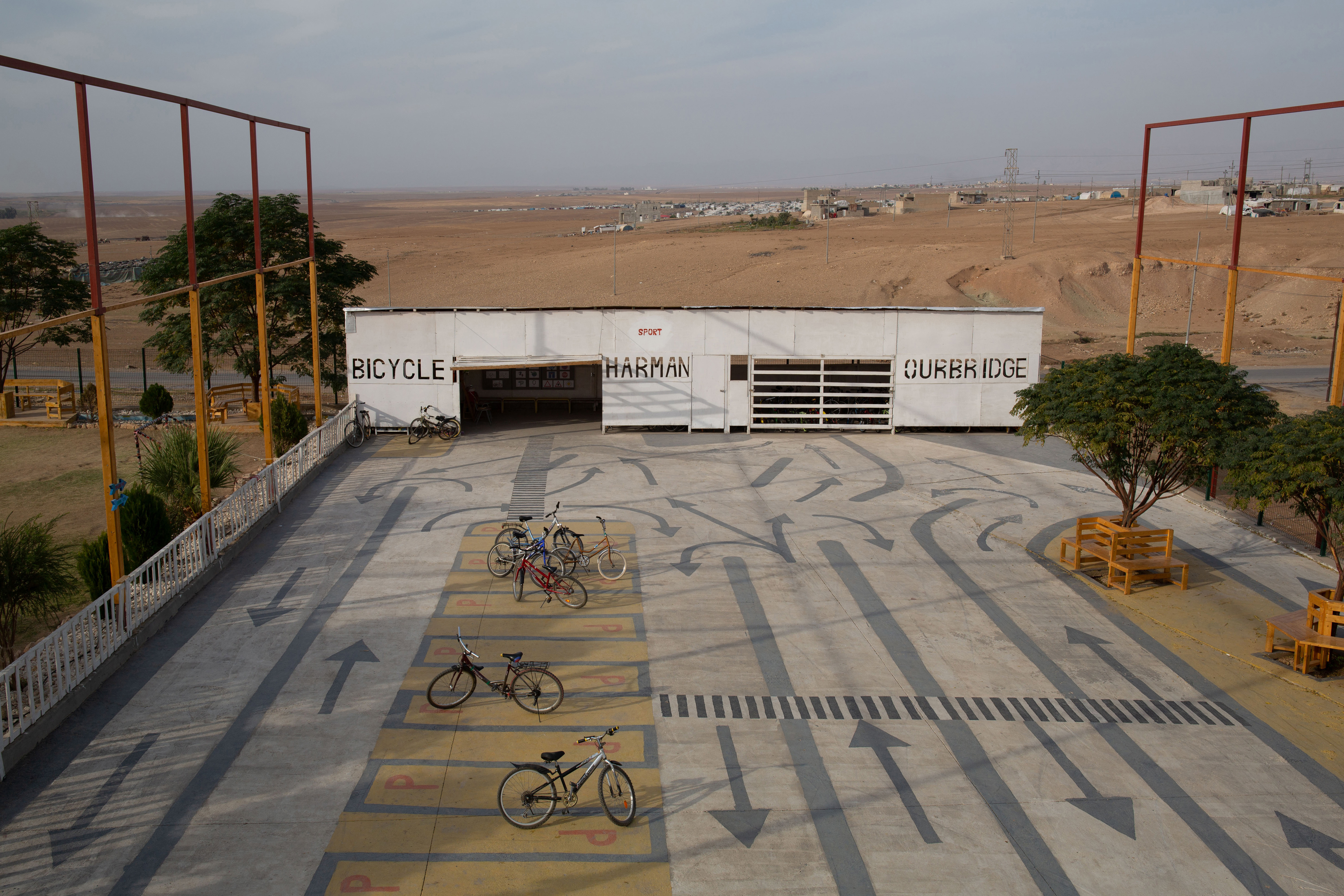 A photo of a parking lot with nothing but a row of bicycles.