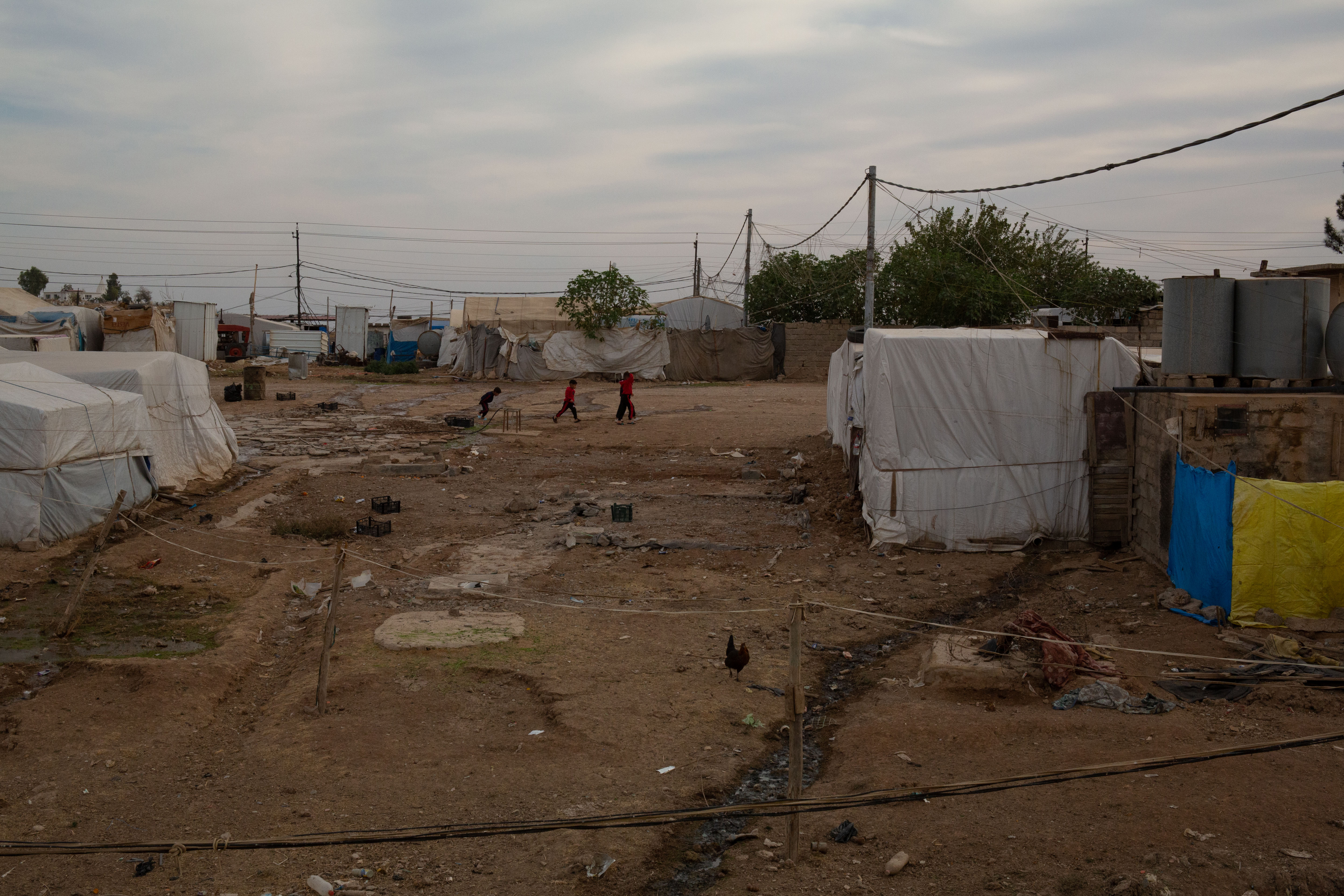 A photo of a camp with makeshift tents made from white cloth.