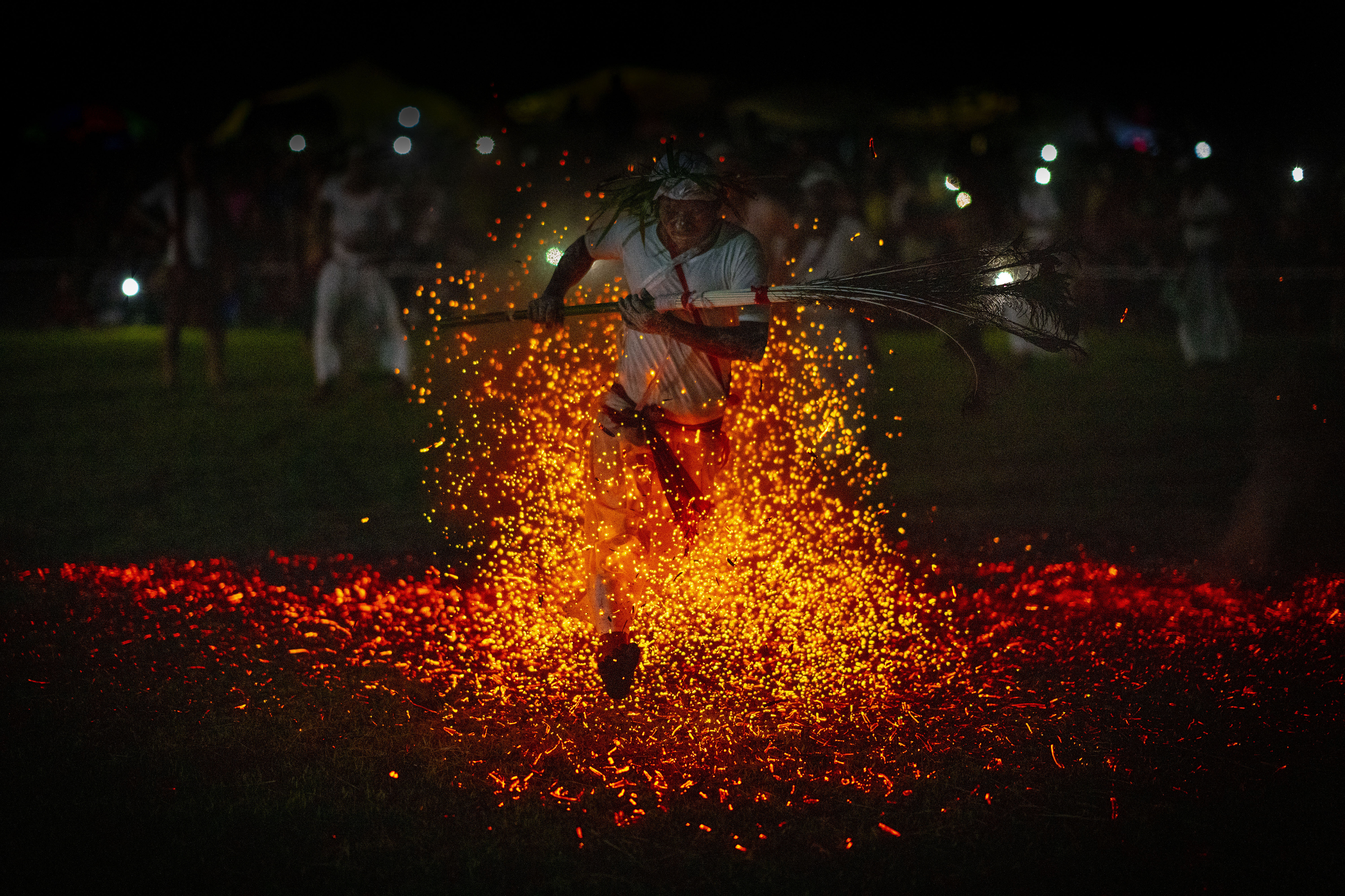 An Indian Rabha tribal Hindu priest runs barefoot over burning charcoal