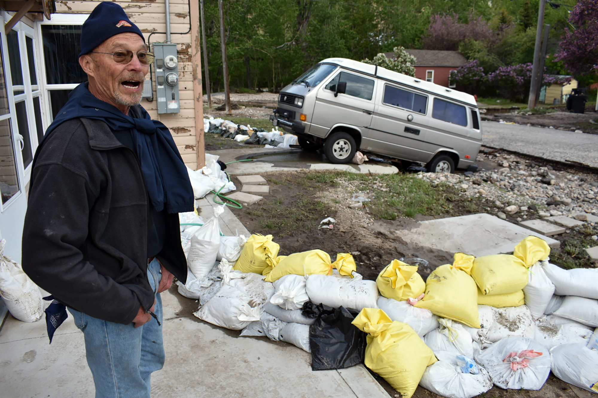 Ken Ebel is seen in front of his flood-damaged house and yard, Tuesday