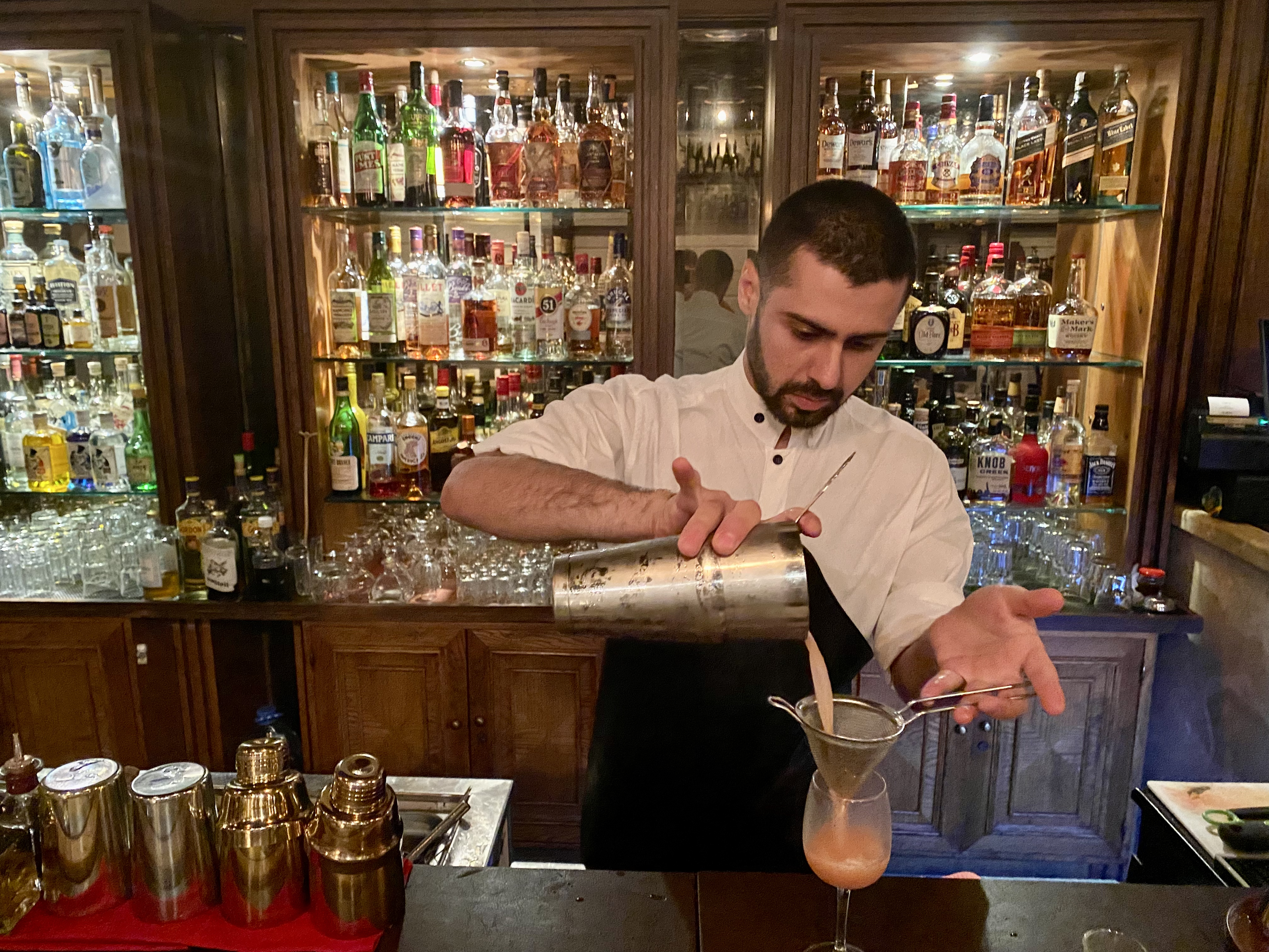 A bartender pours a drink at a bar