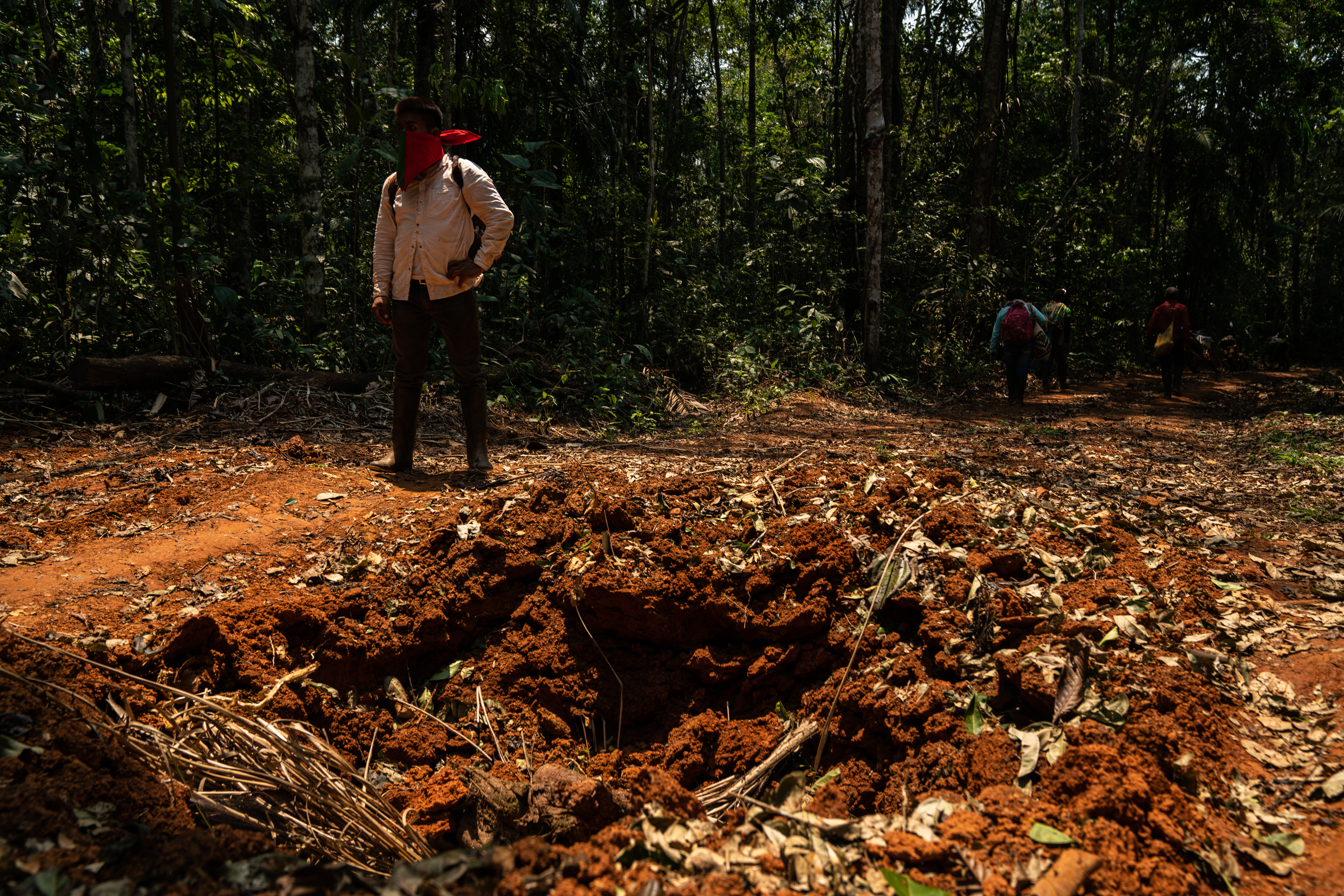 Community members assess a road destroyed in Operation Artemis