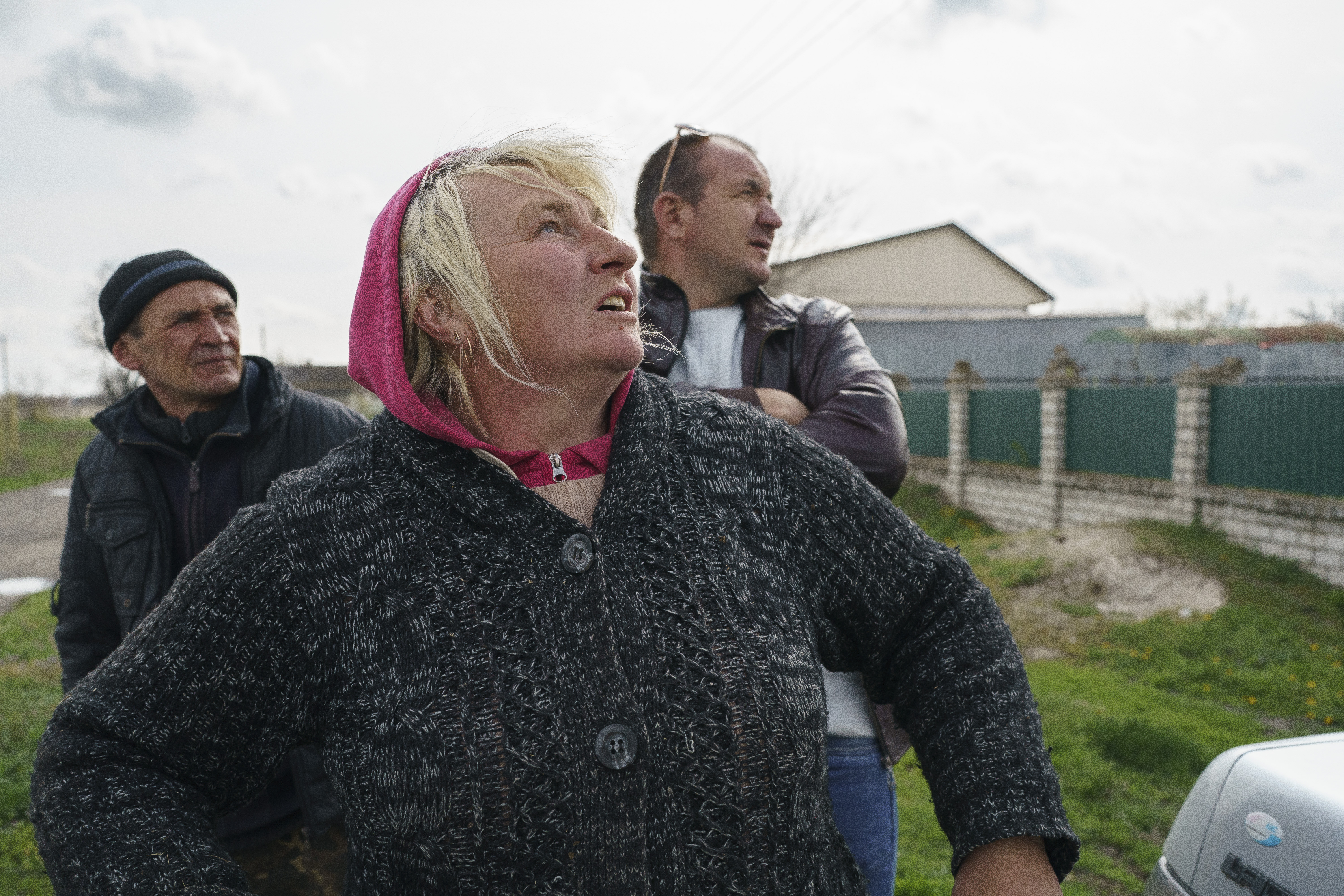 Victor(L), Ivan (R) and Lubov, are watching the missiles that are a few km's away. They had to stay in Shevchenko village because they had nowhere to go due to economical reasons.