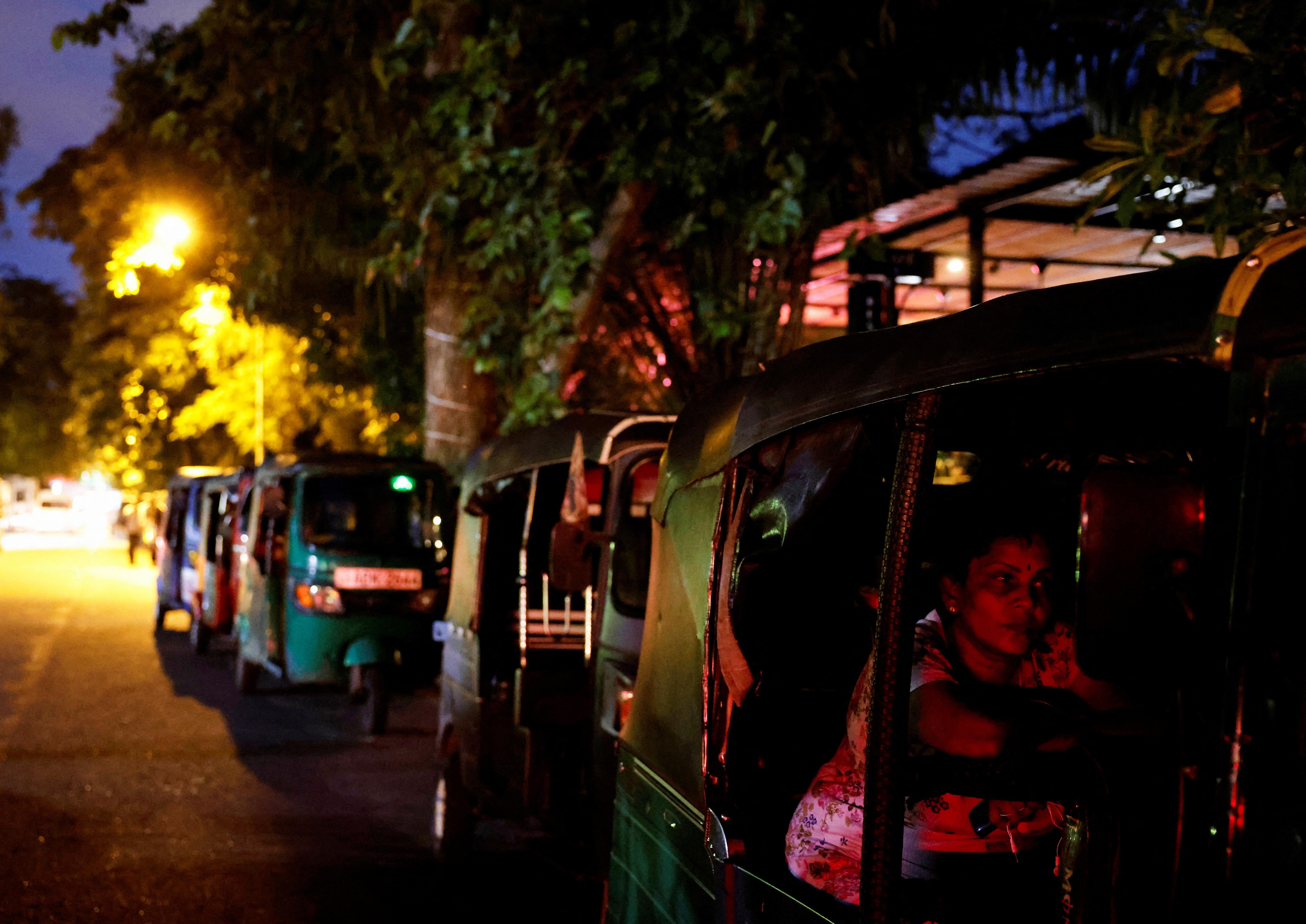 A woman waits in an autorickshaw at a queue for buying petrol due to fuel shortage, amid the country's economic crisis, in Colombo, Sri Lanka
