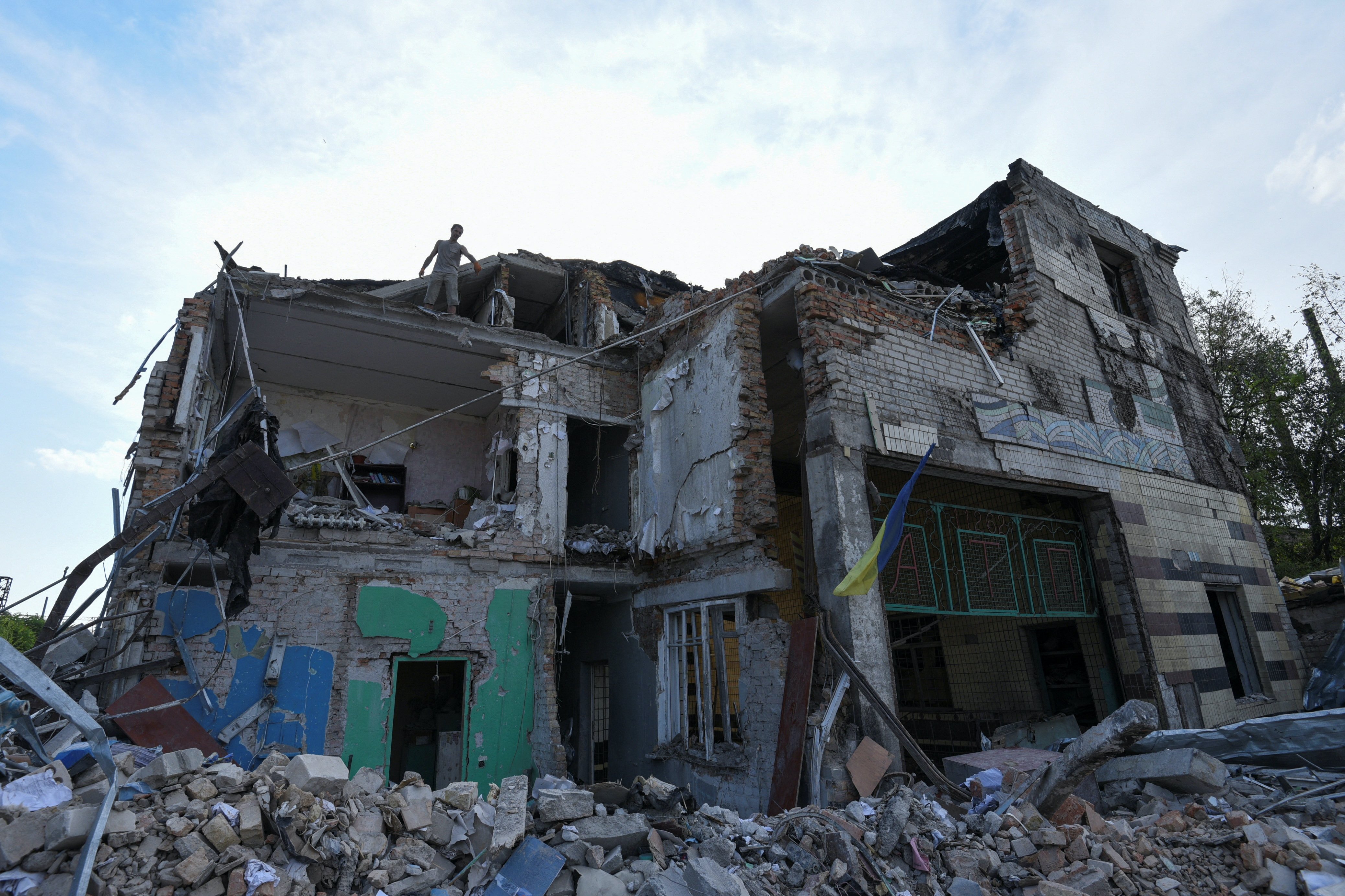 A worker removes debris from a building of a car garage destroyed by a Russian missile strike, as Russia's attack on Ukraine continues, in Dnipro, Ukraine