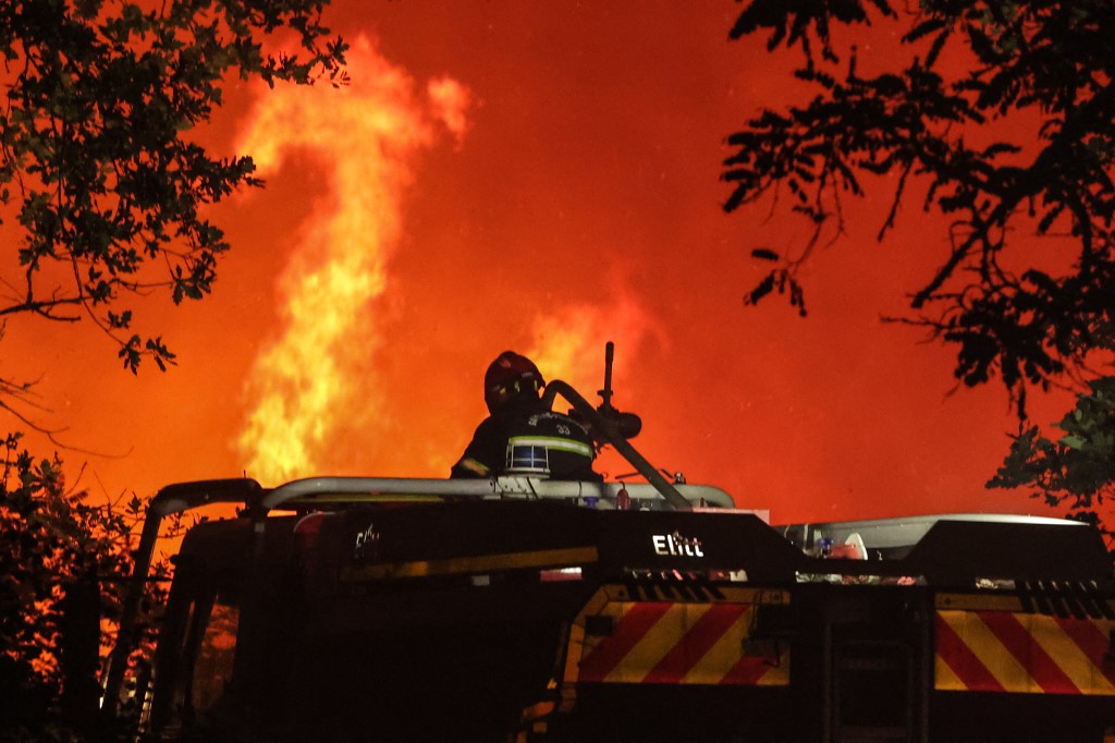 Firefighters attempt to control a forest fire in France