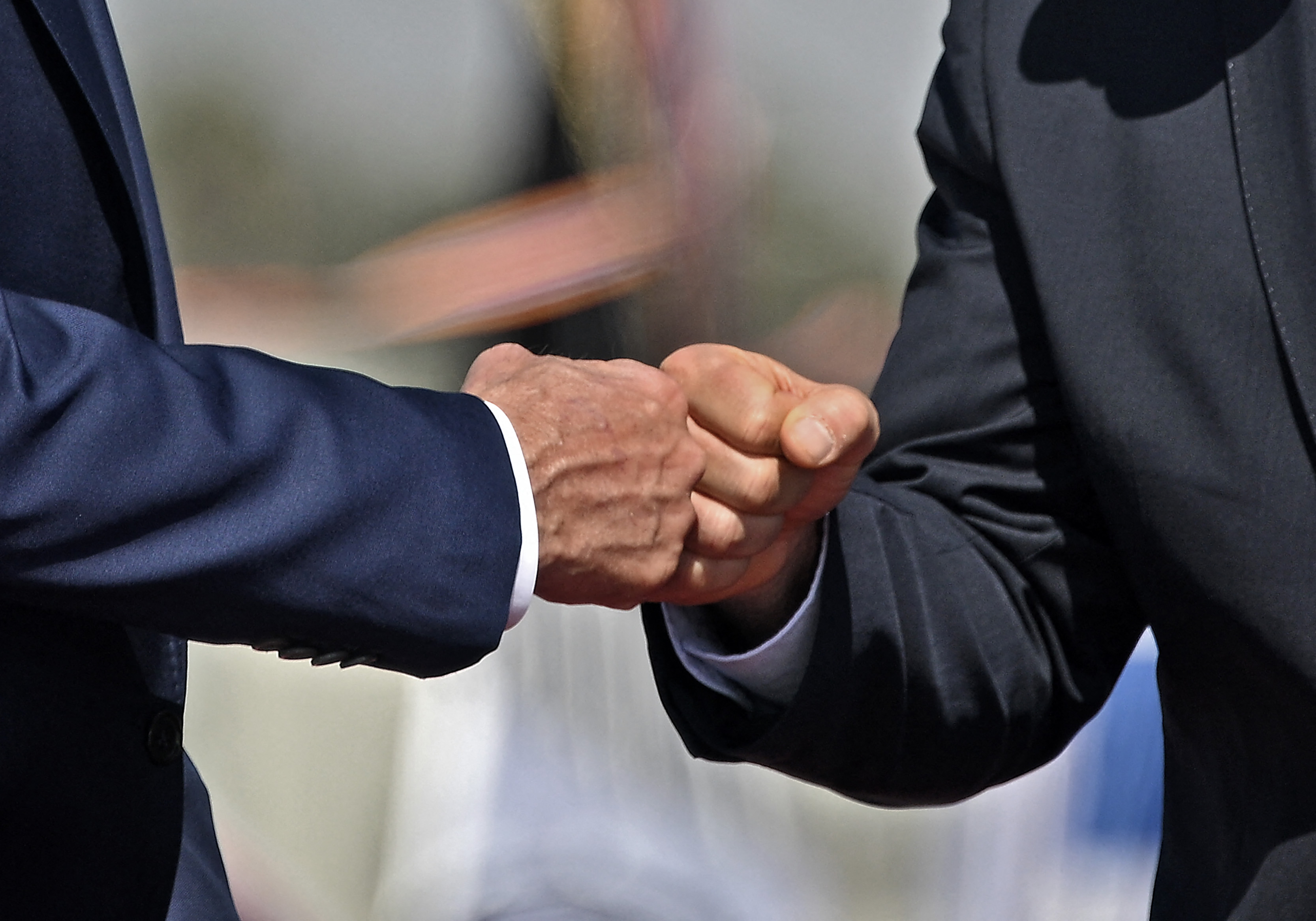 Israel's caretaker Prime Minister Yair Lapid (R) and US President Joe Biden bump fists upon the latter's arrival at Ben Gurion Airport in Lod near Tel Aviv