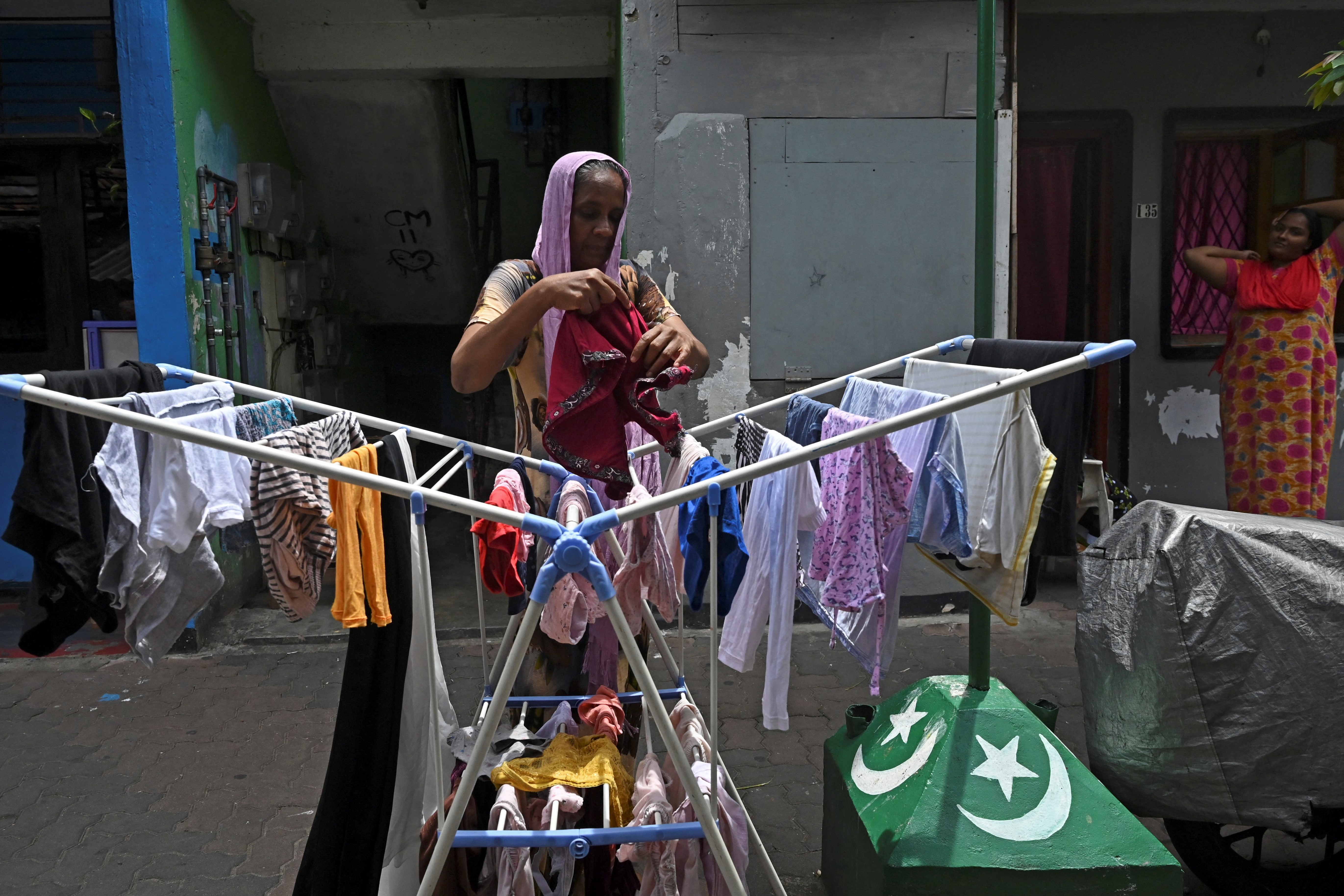 a resident hanging laundry in an alleyway in the Slave Island