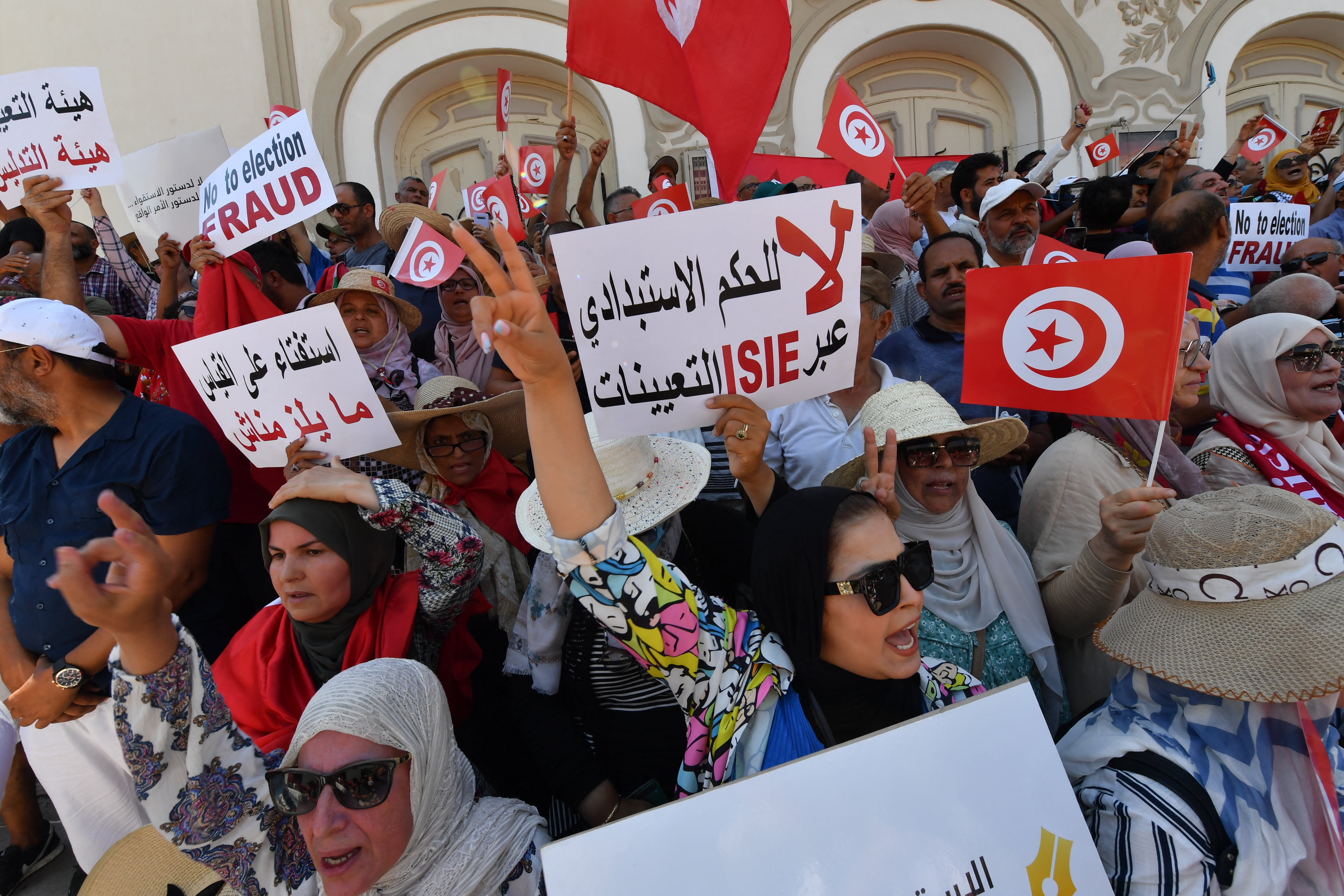 Tunisian protesters raise a flag