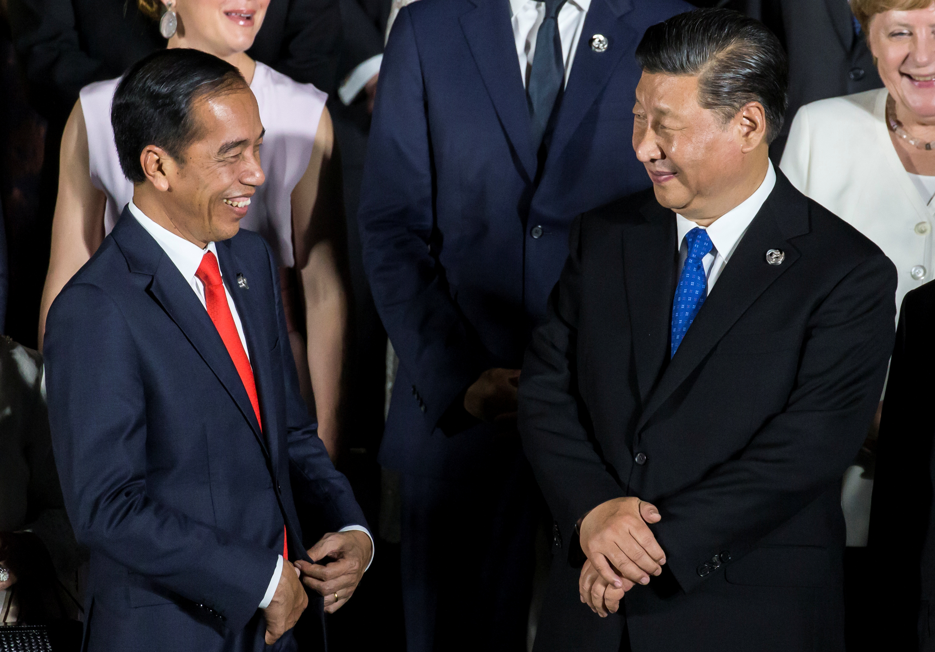 Indonesia's President Joko Widodo speaks to China's President Xi Jinping during a family photo session in front of Osaka Castle at the G-20 summit, in Osaka, Japan in June 2019.
