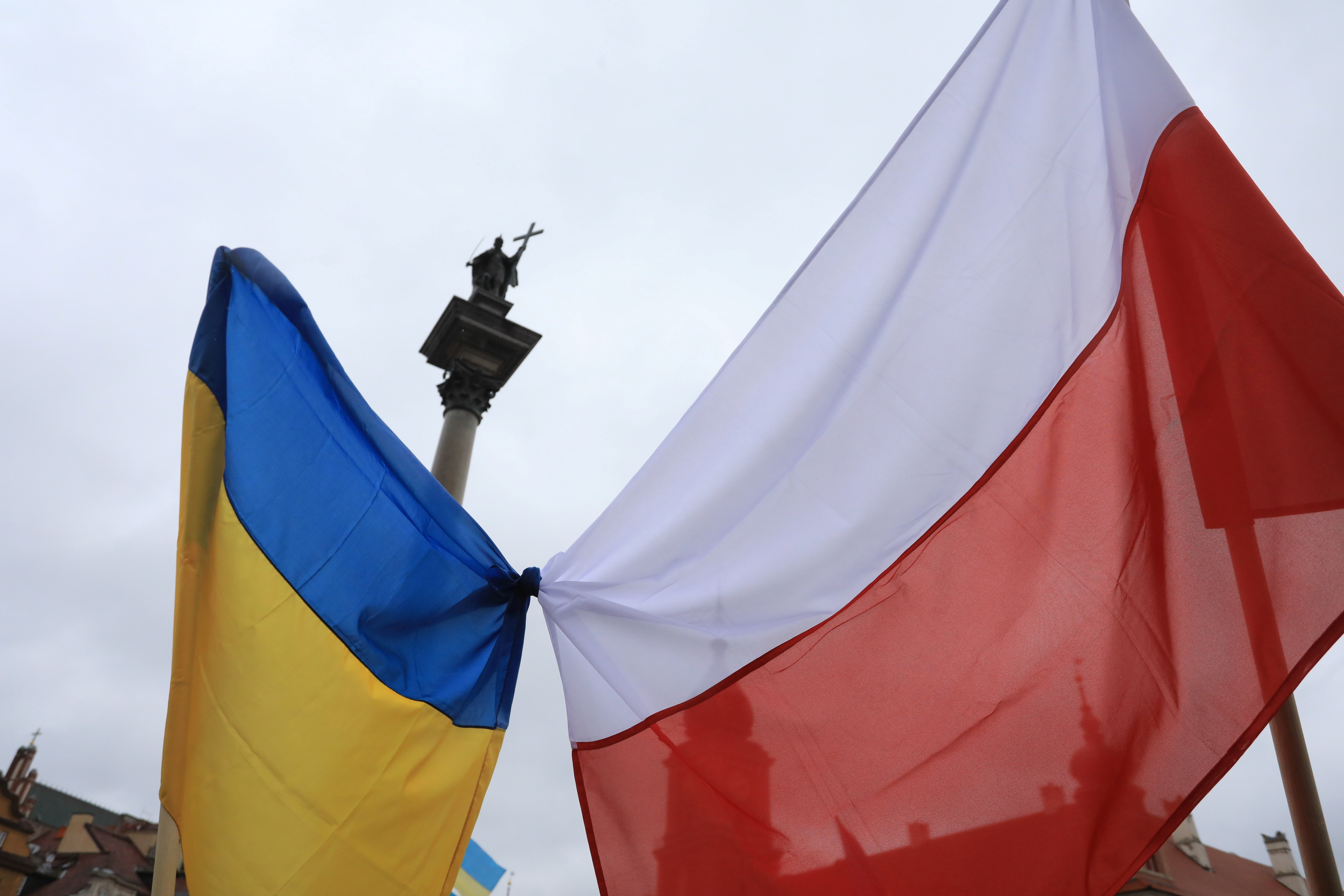People wave Polish and Ukrainian flags during a demonstration in solidarity with Ukraine in Warsaw, Poland in February 2022 [Jacek Marczewski/Agencja Wyborcza.pl via Reuter