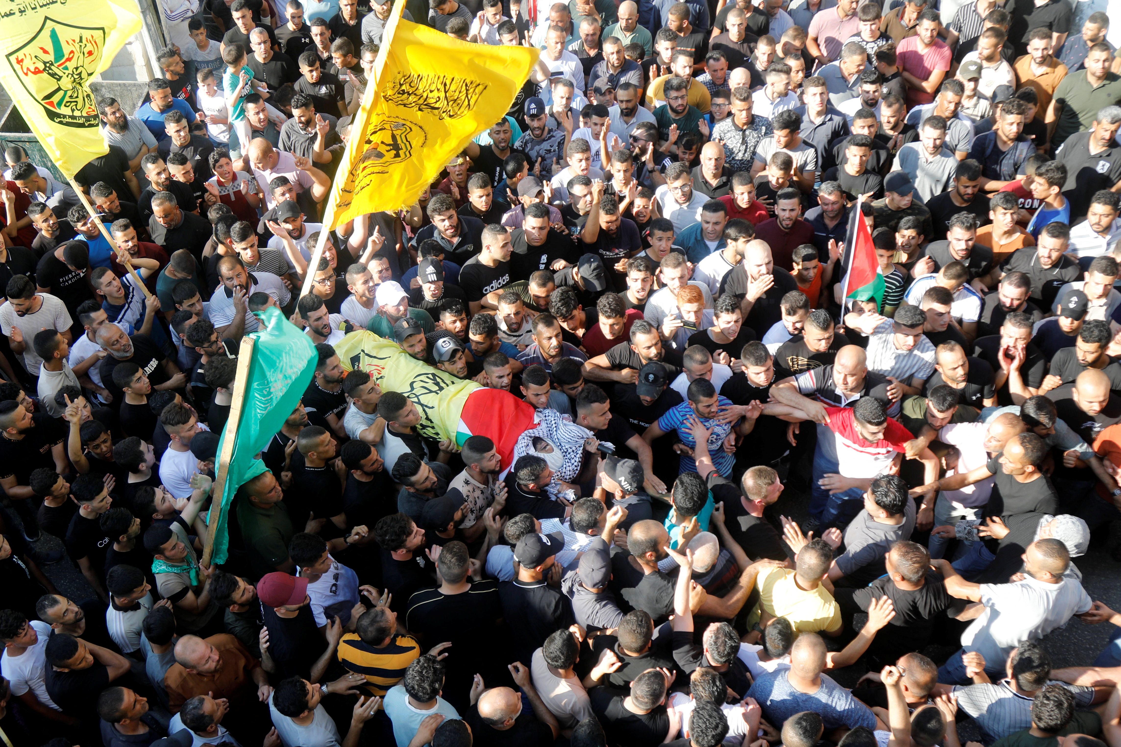 Mourners carry the body of Kamel Alawneh, who succumbed to wounds sustained during an Israeli raid, during his funeral in Jenin