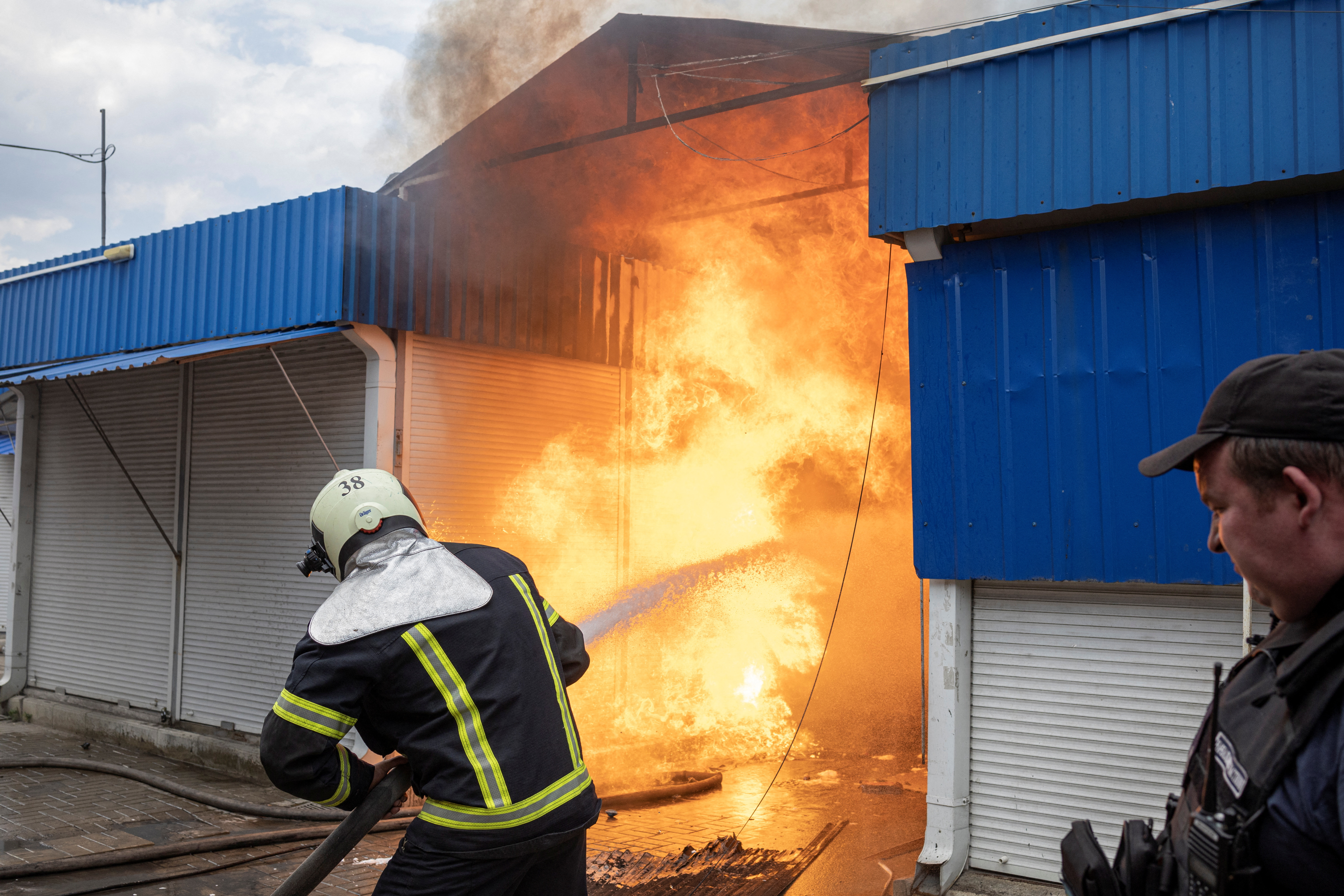 Firefighters spray water onto fire at the market after shelling, as Russia?s attack on Ukraine continues, in Sloviansk