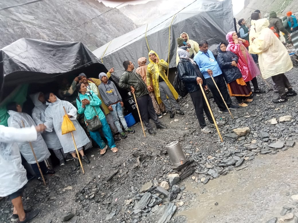 People stand outside tents after a cloudburst near the holy Amarnath cave shrine