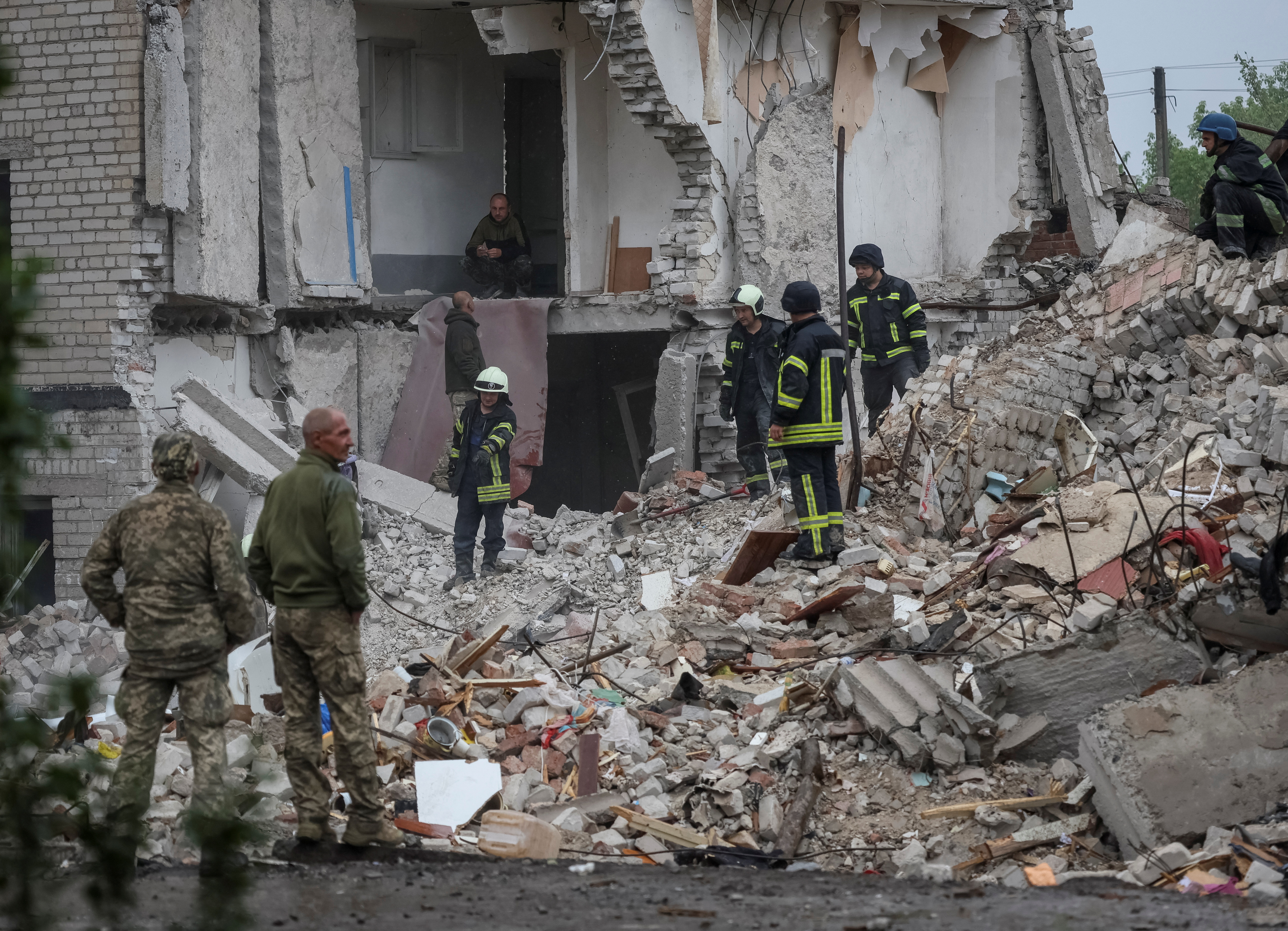 Rescuers work at a residential building damaged by a Russian military strike in the town of Chasiv Yar
