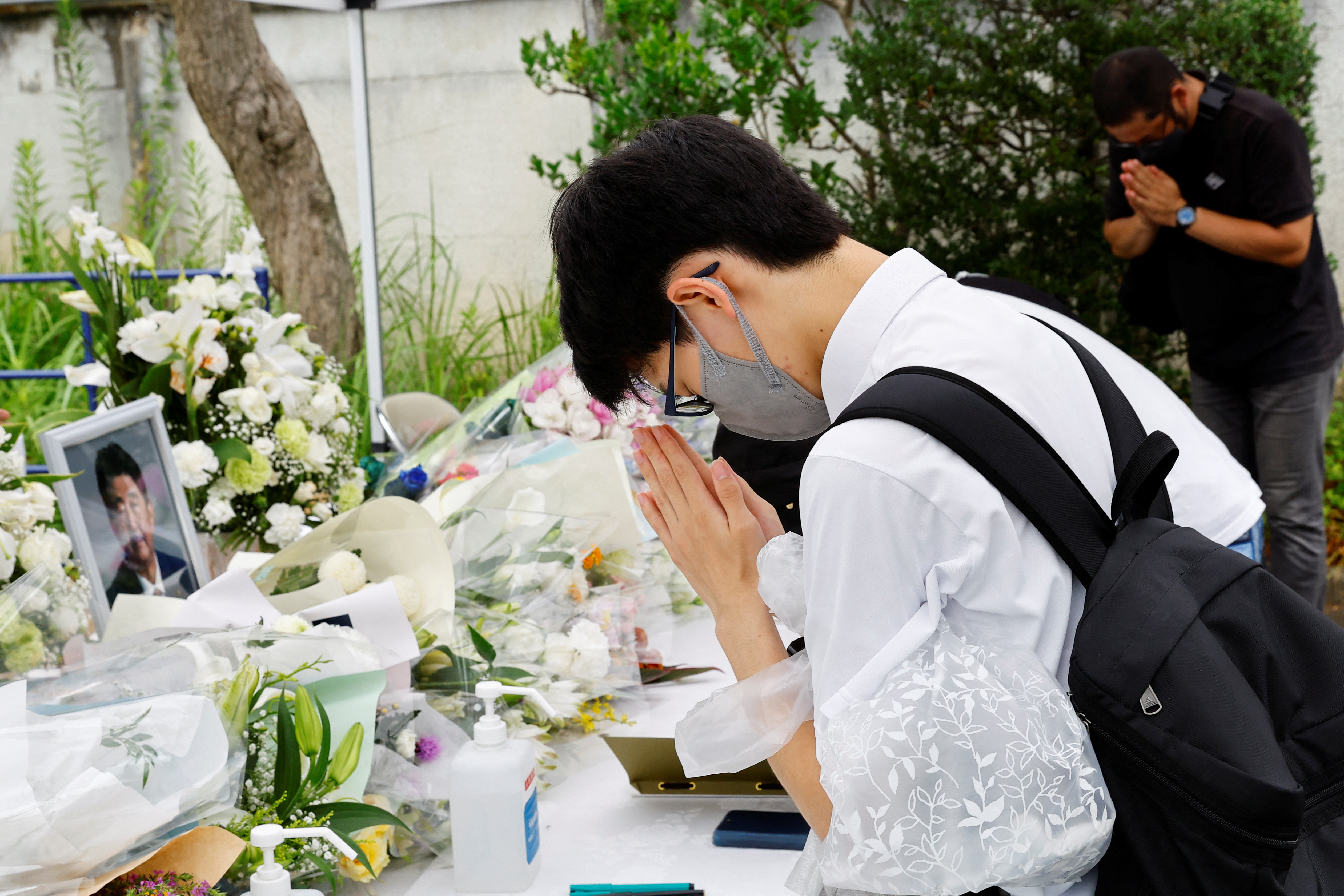 Mourners pray for late former Japanese Prime Minister Shinzo Abe, who was shot while campaigning for a parliamentary election, at Headquarters of the Japanese Liberal Democratic Party