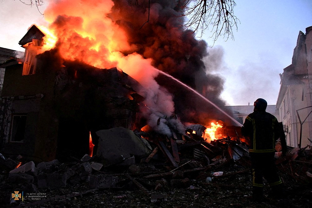 A firefighter works at a site of a residential building damaged by a Russian military strike, as Russia's attack on Ukraine continues, in Mykolaiv, Ukraine
