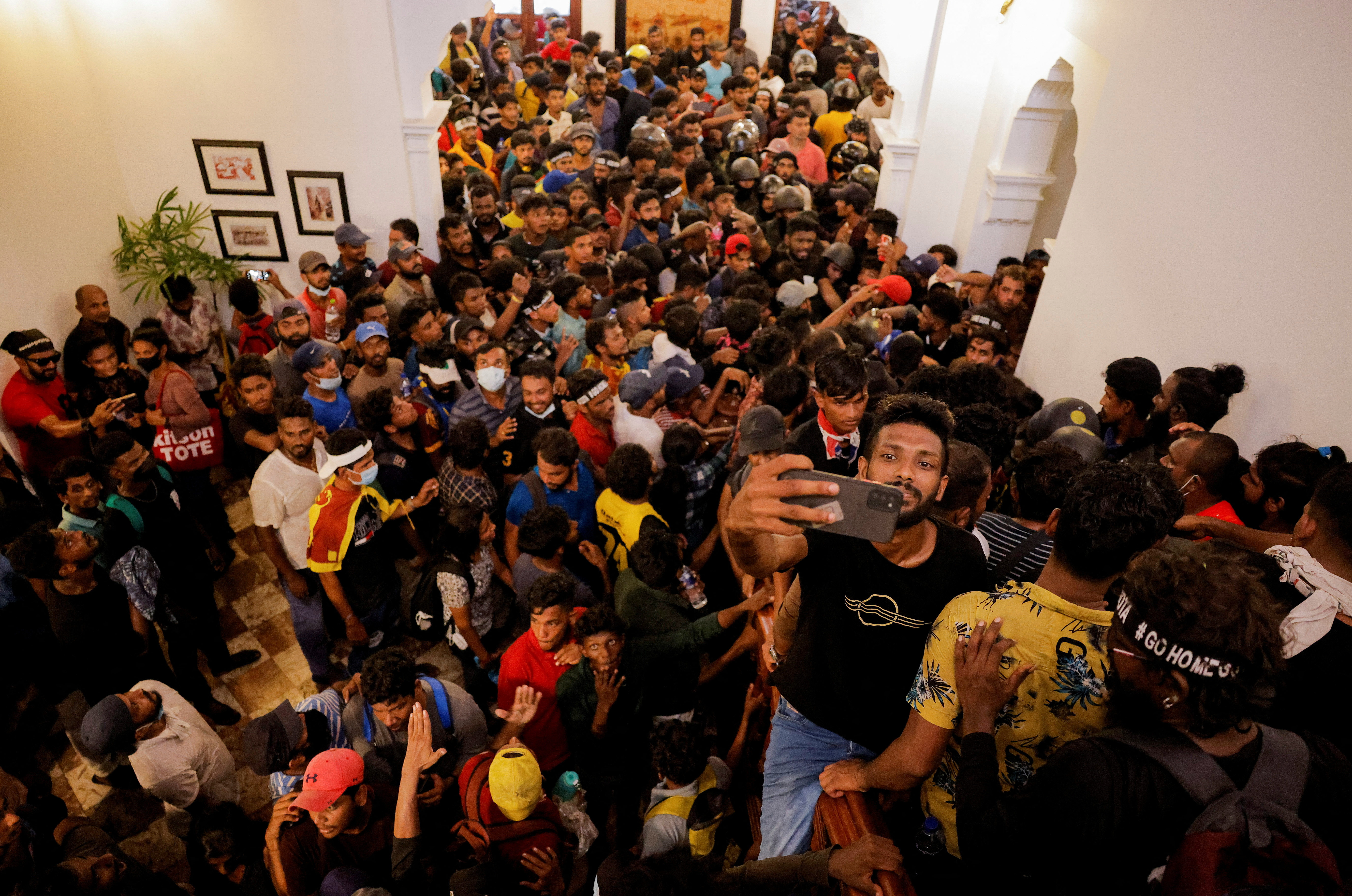 Demonstrators wait to enter into Sri Lankan Prime Minister Ranil Wickremasinghe's office during a protest demanding for his resignation, after President Gotabaya Rajapaksa fled, amid the country's economic crisis, in Colombo