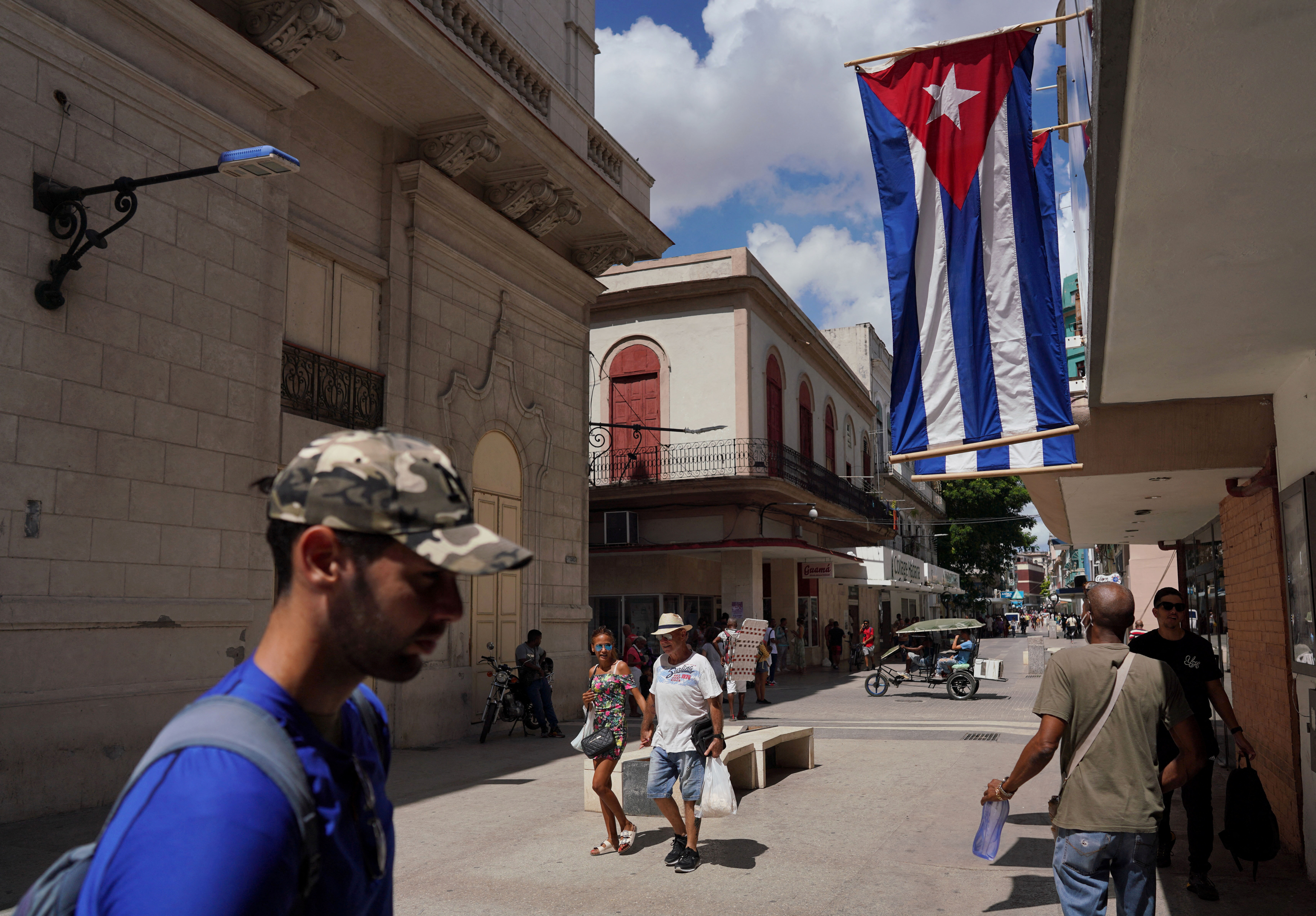 Cuban flags are displayed at a commercial road in downtown Havana