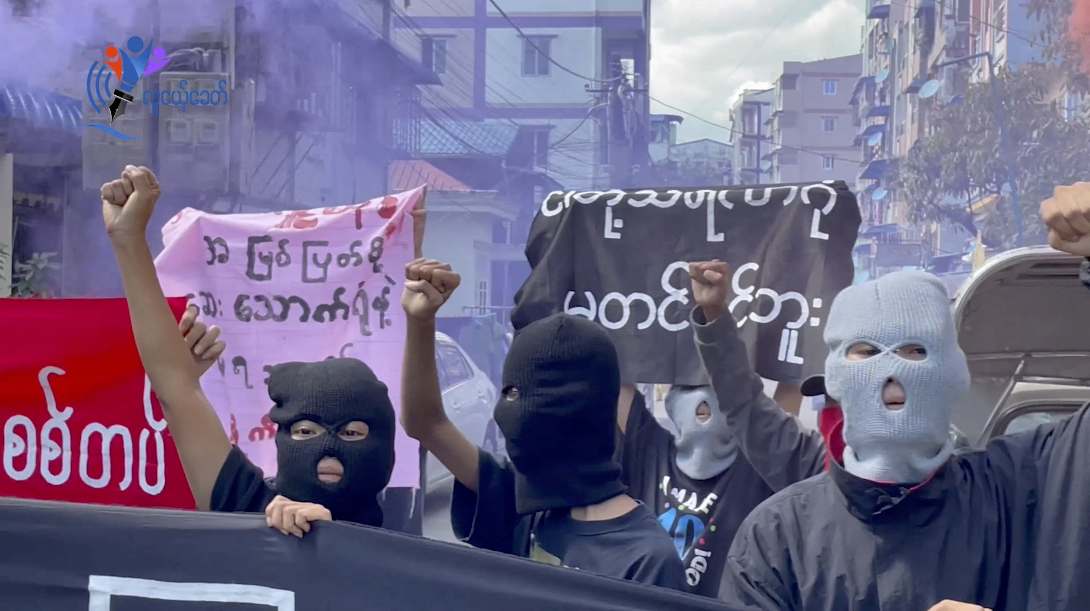Prosters in black balaclavas march on the street in Yangon following the execution of four pro-democracy activists and politicians