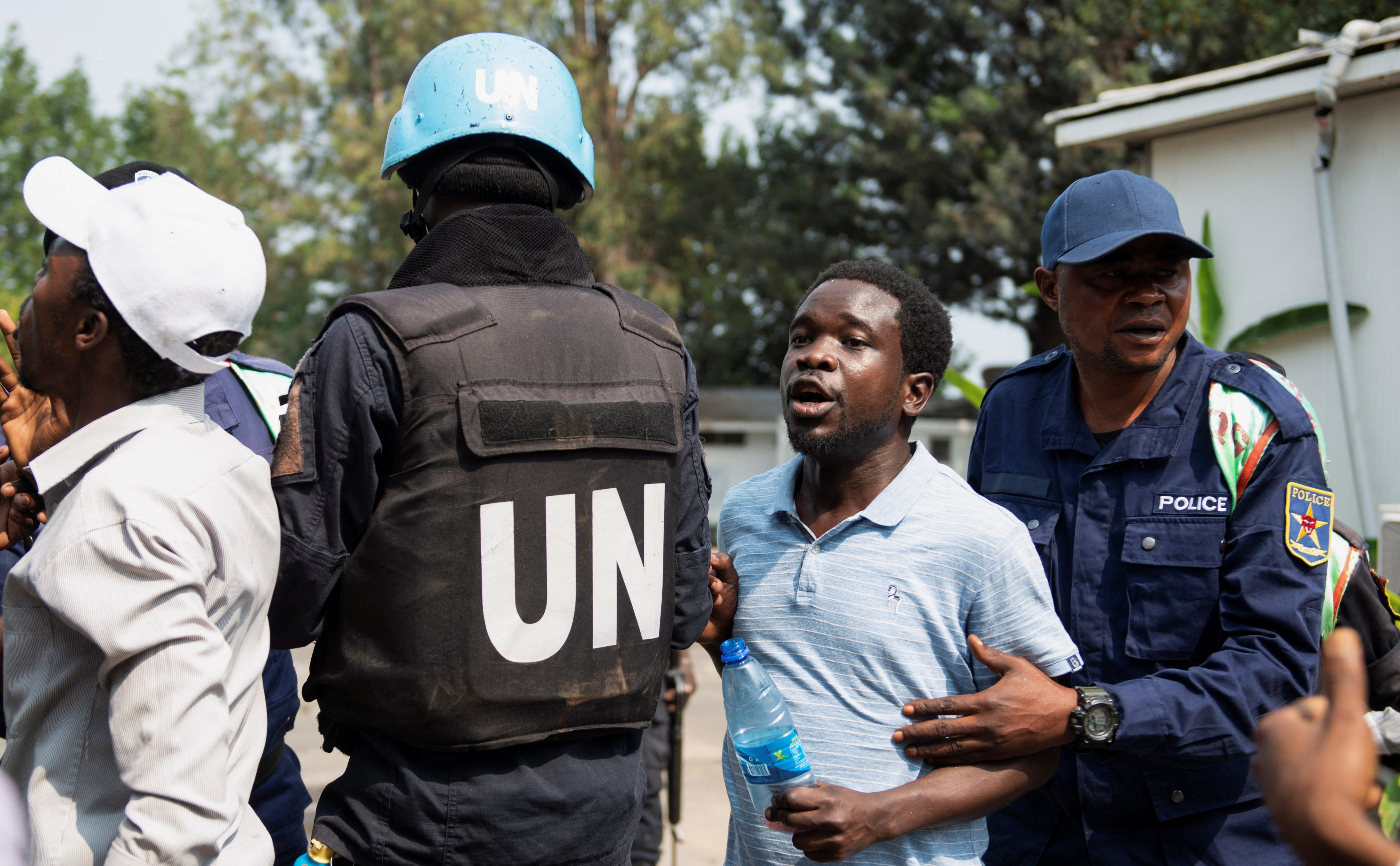 A Congolese policeman and a United Nations Organization Stabilization Mission in the Democratic Republic of the Congo (MONUSCO) peacekeeper attempt to stop protesters inside the compound of a United Nations peacekeeping force's warehouse in Goma in the North Kivu province of the Democratic Republic of Congo