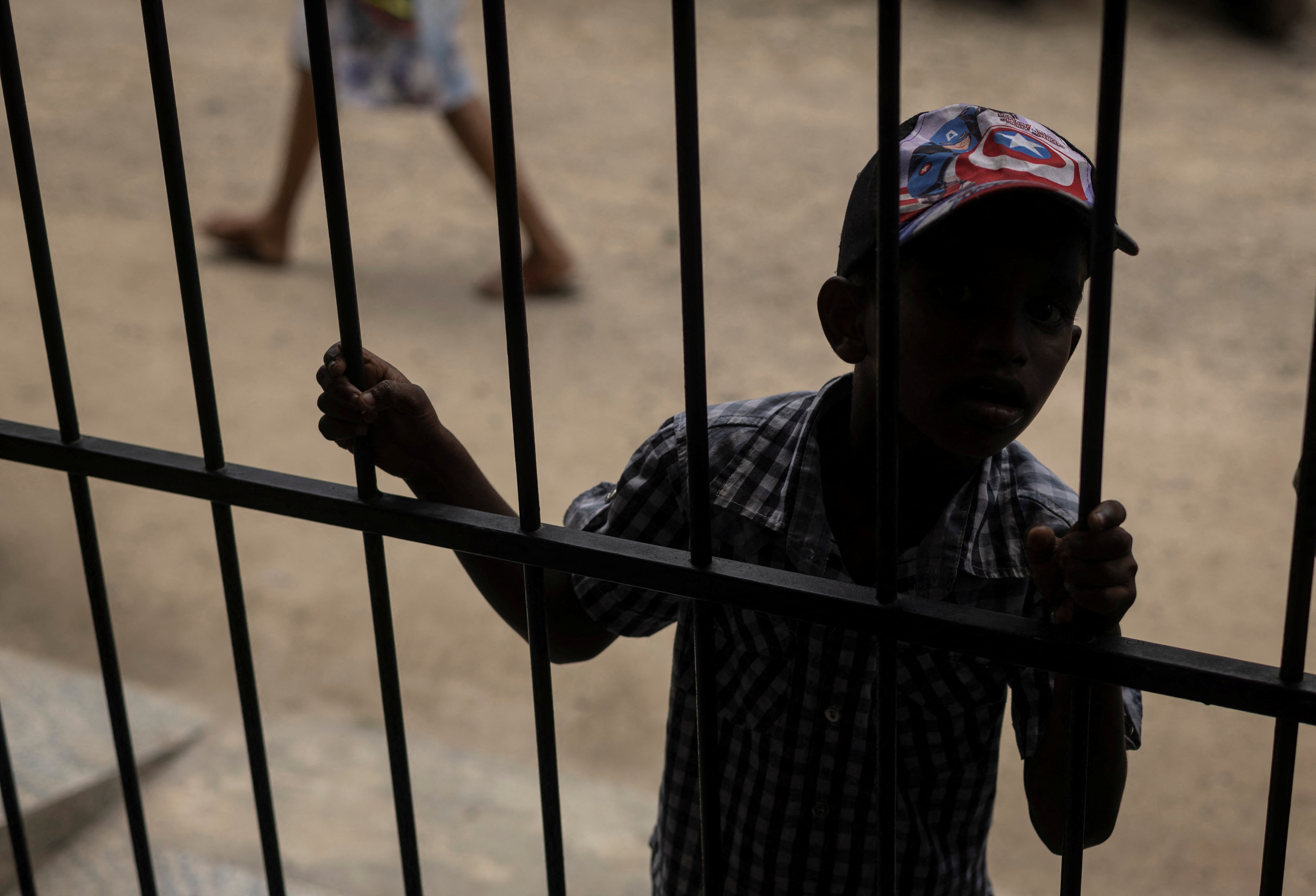 A boy waits to receive food at a community kitchen
