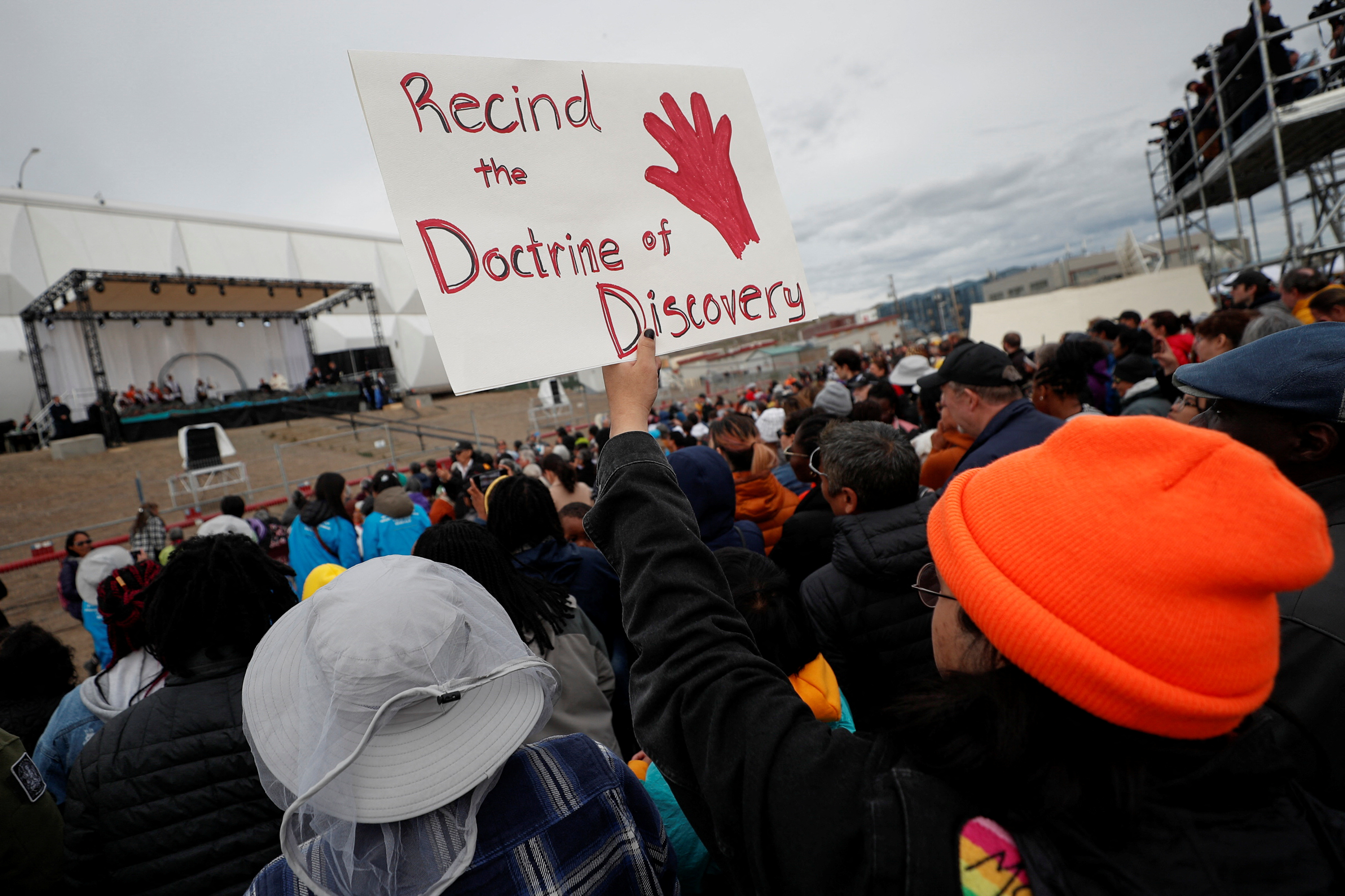 A person holds a protest sign urging the pope to rescind the Doctrine of Discovery during the event in Iqaluit, Nunavut, July 29, 2022