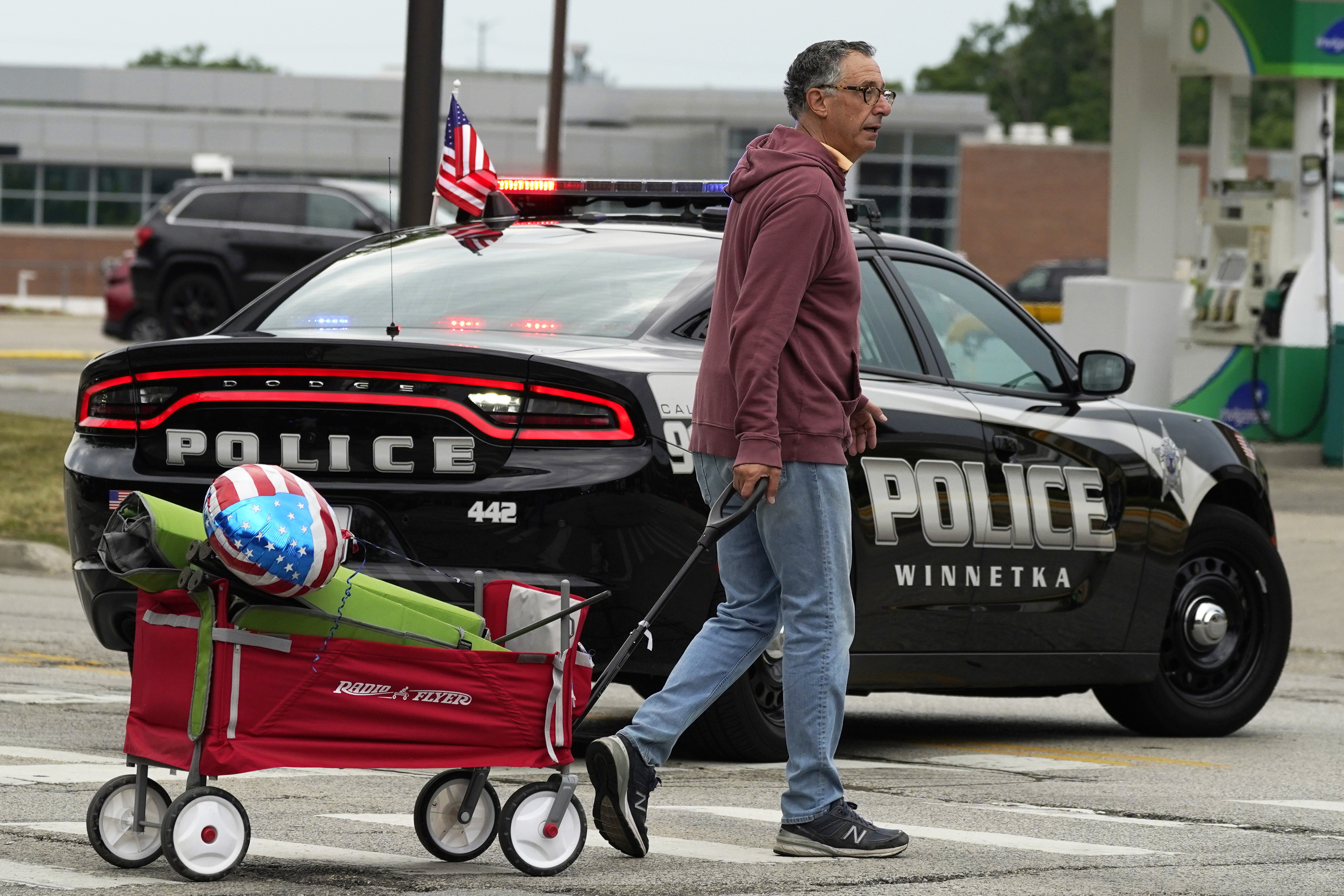 A man carries his belongings after a mass shooting at the Highland Park Fourth of July