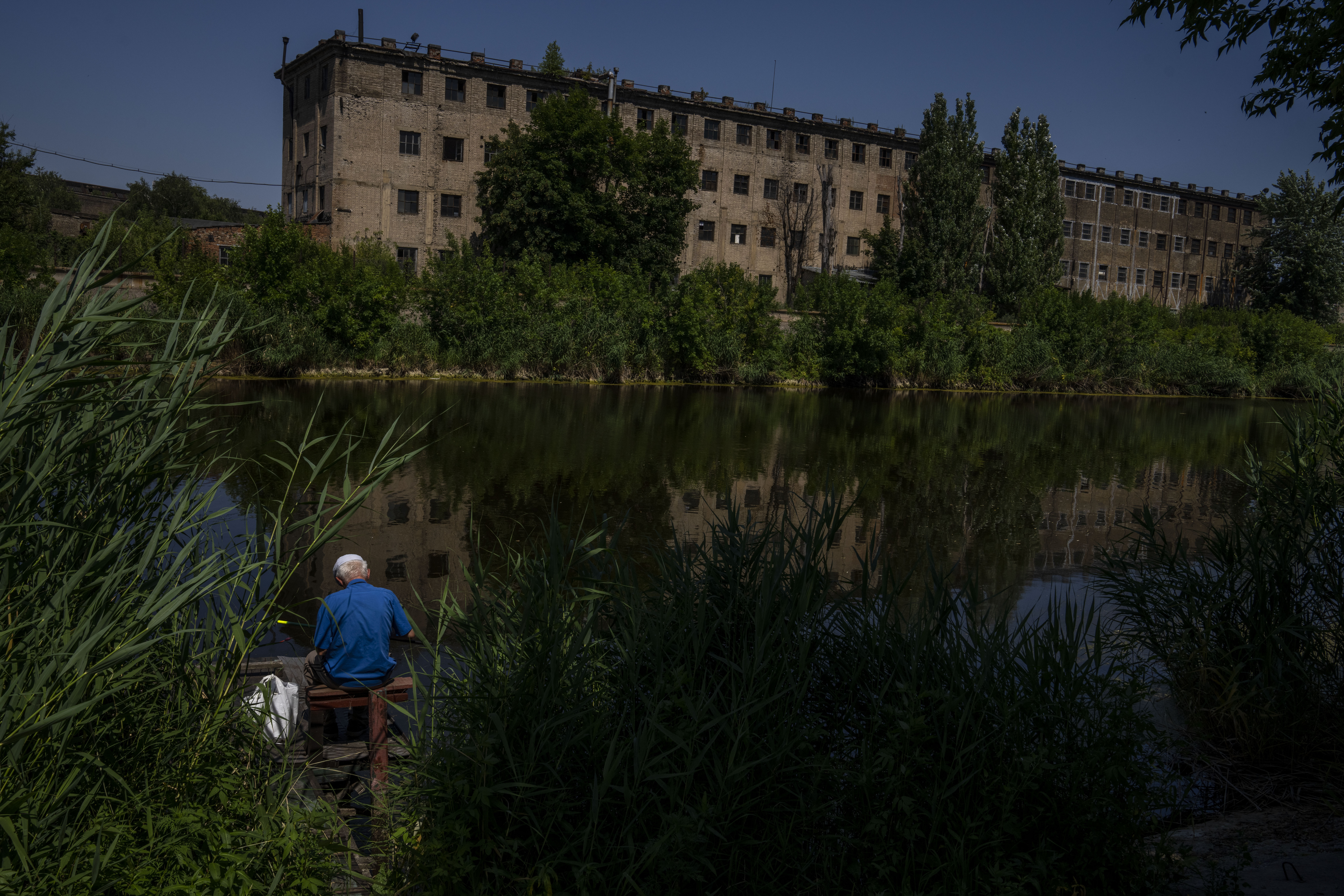 A fisherman resident who refuses to evacuate his hometown, fishes by the river, in Kramatorsk, eastern Ukraine