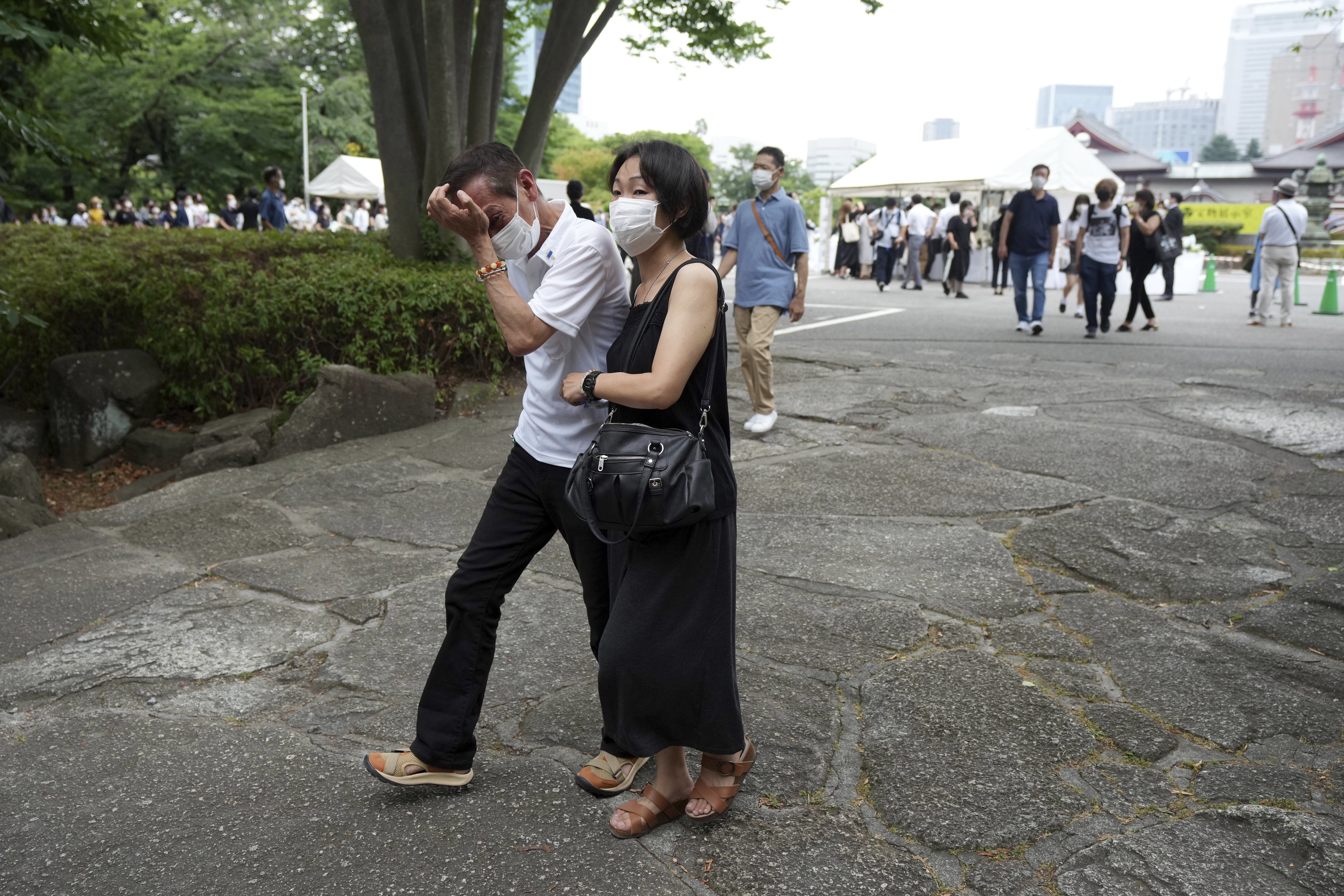 One of people who offer flowers and prayers for former Prime Minister Shinzo Abe, cries at Zojoji temple