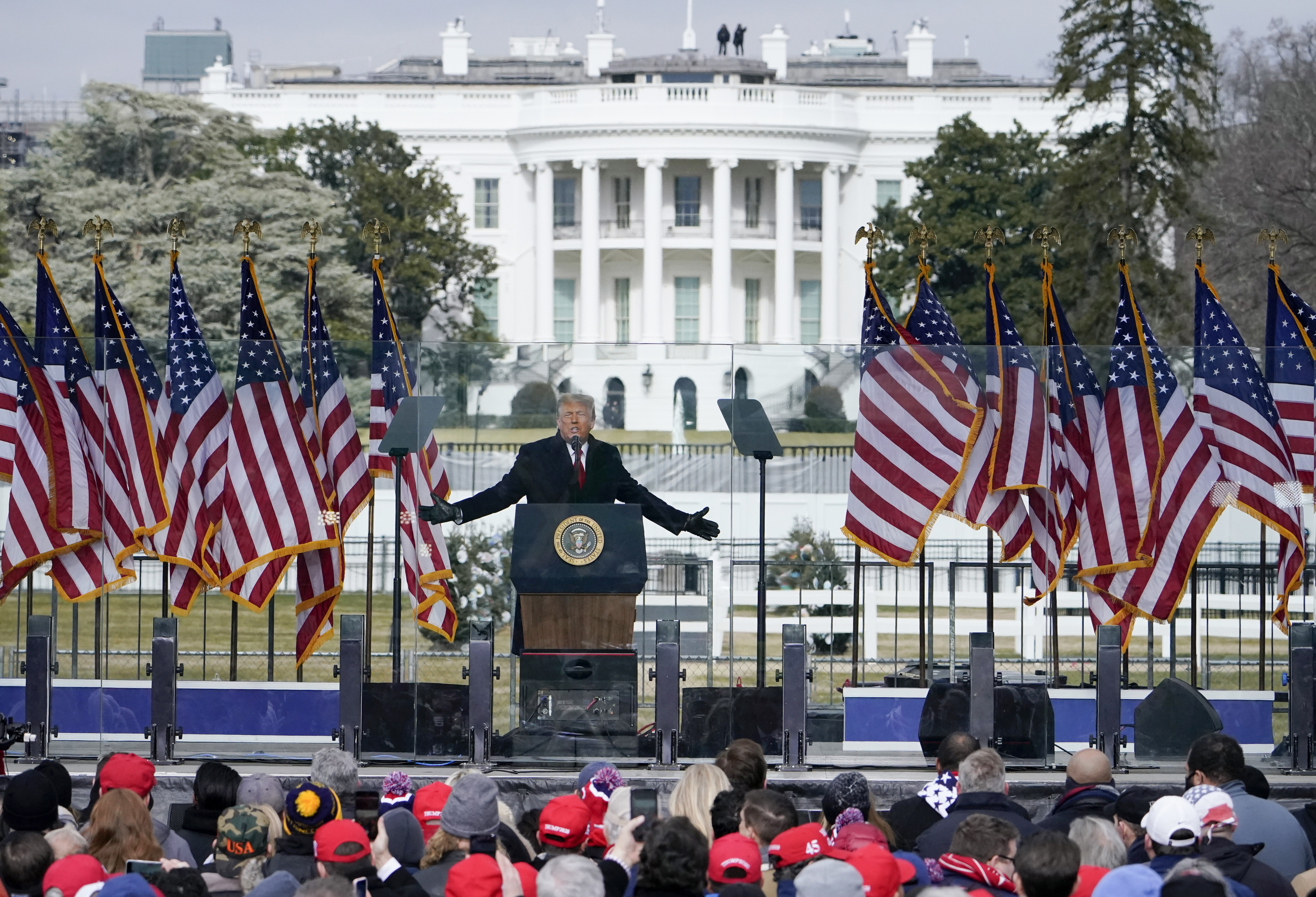 Trump giving a speech in front of the White House.