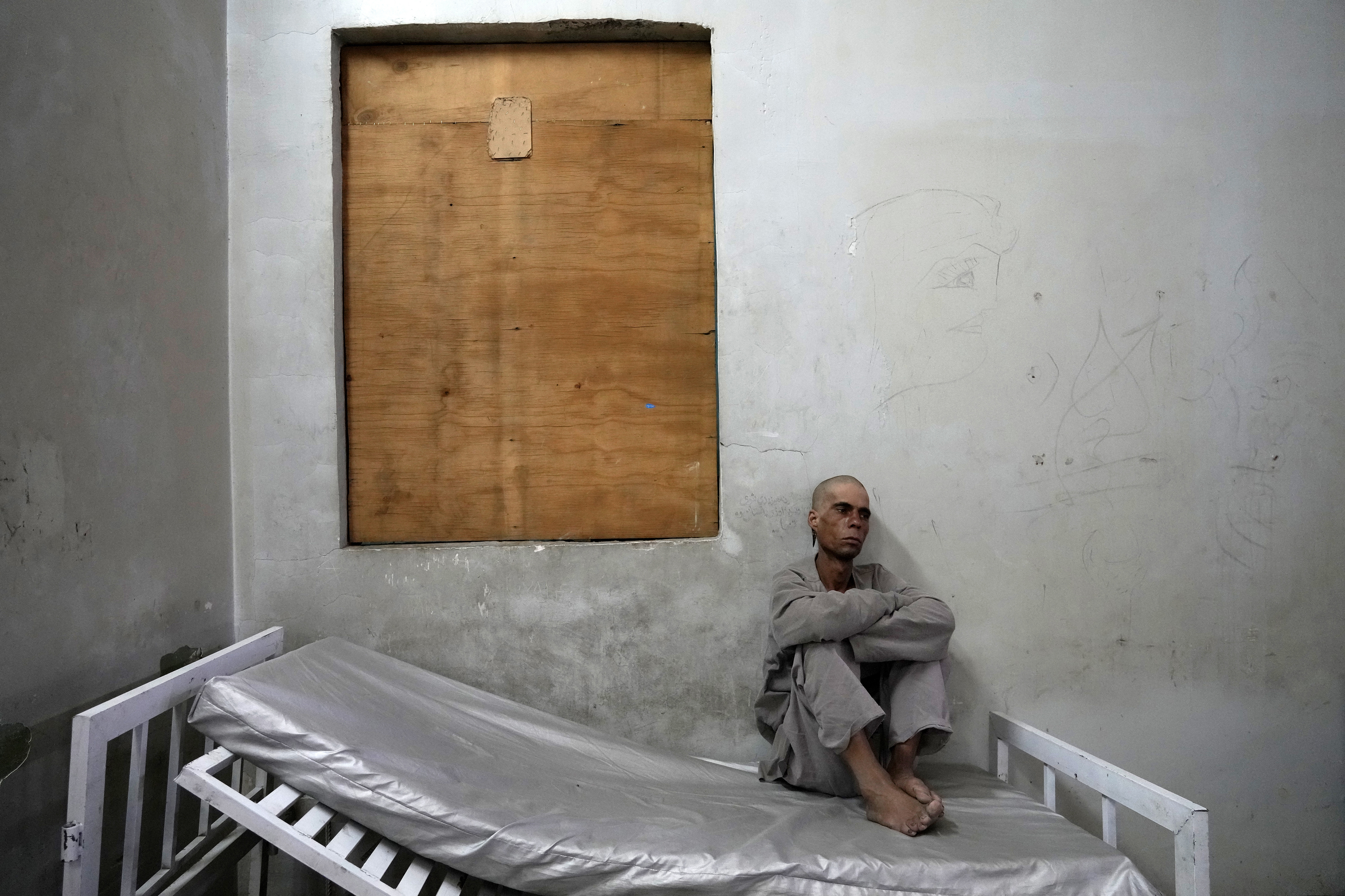 A drug addict sits on his bed in the detoxification ward