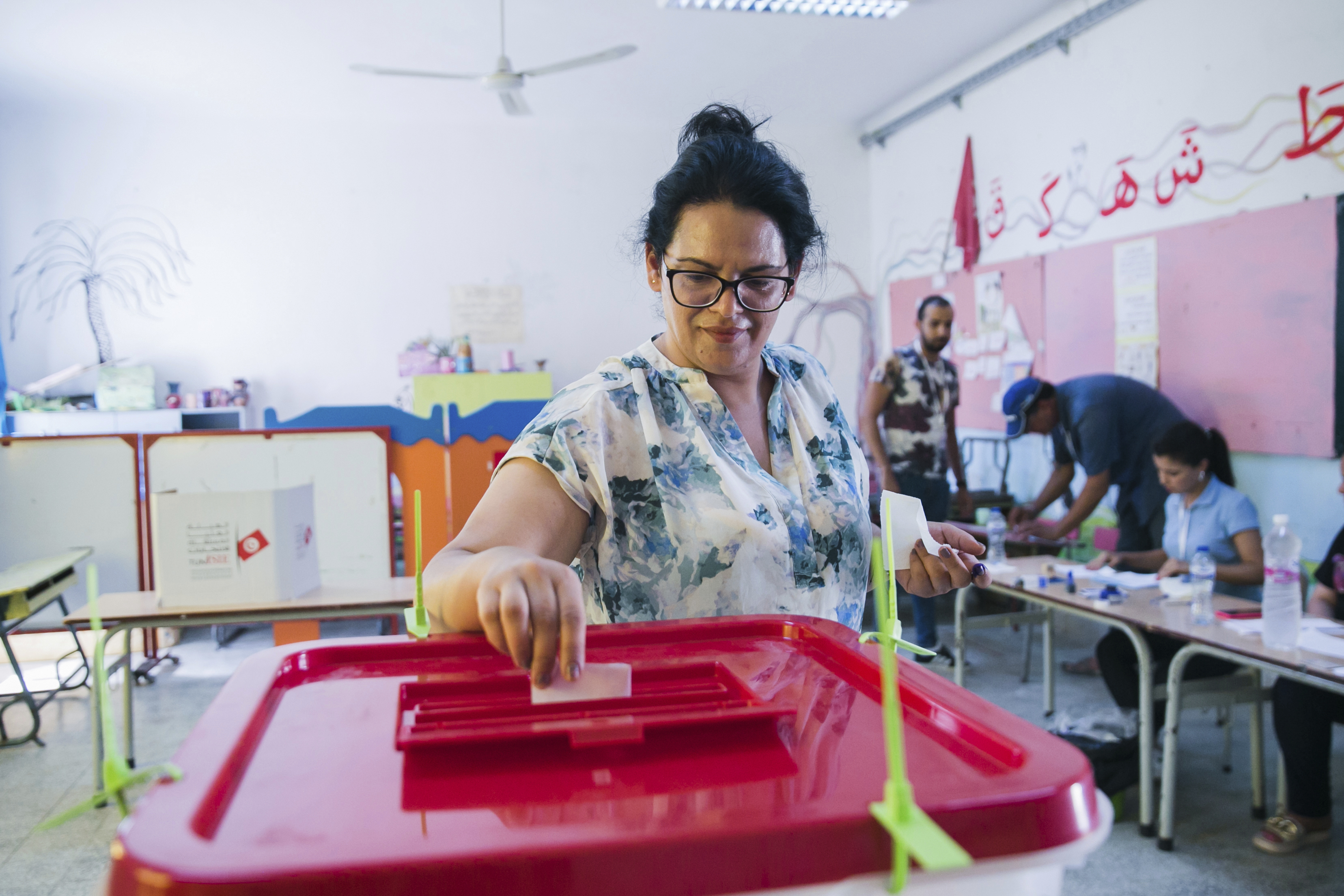 A Tunisian woman casts her vote on a new constitution at a polling station.