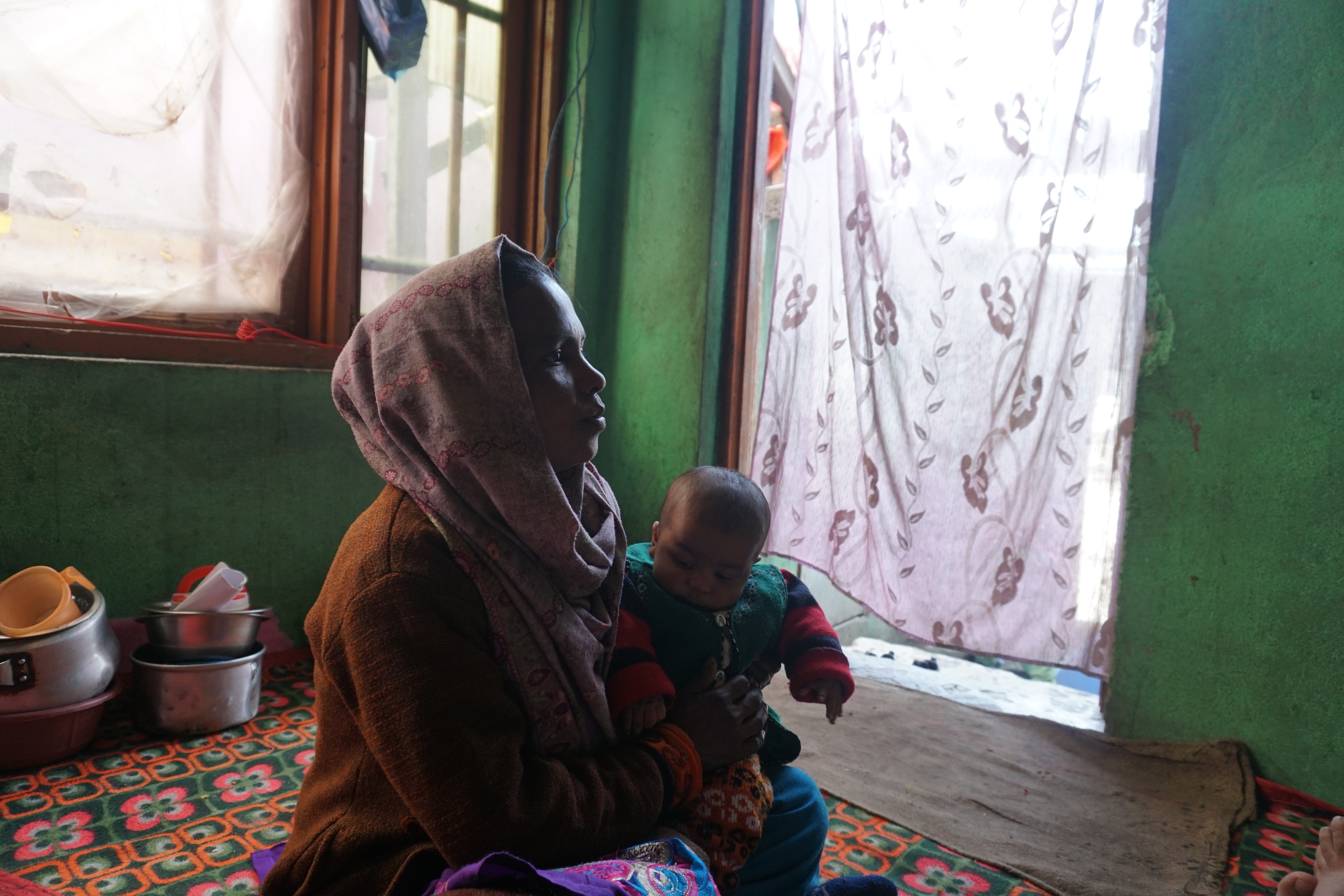 A photo of a woman holding a baby in her lap.