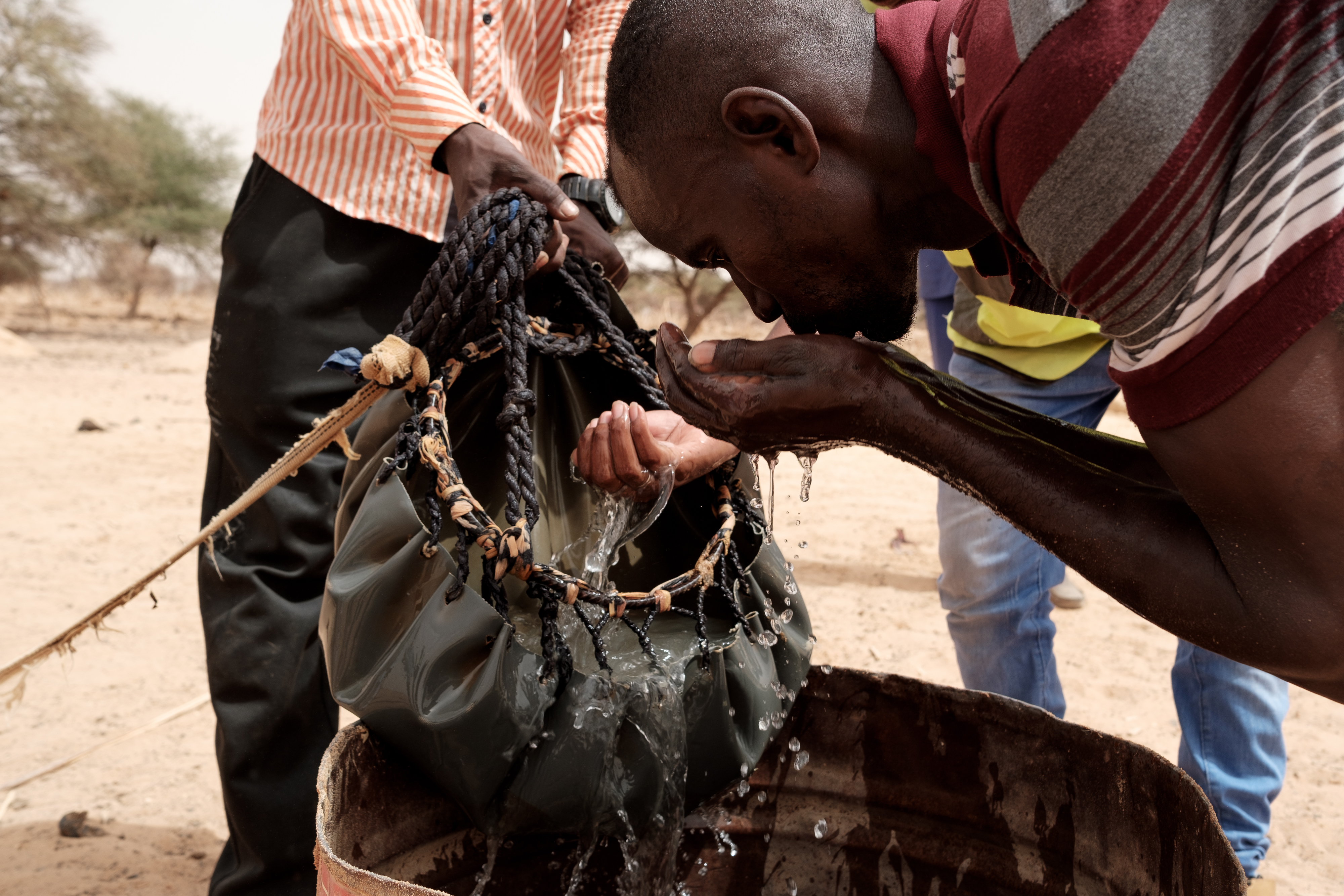 A villager from Lemghaysse village drinks from a bucket lifted from one of the wells