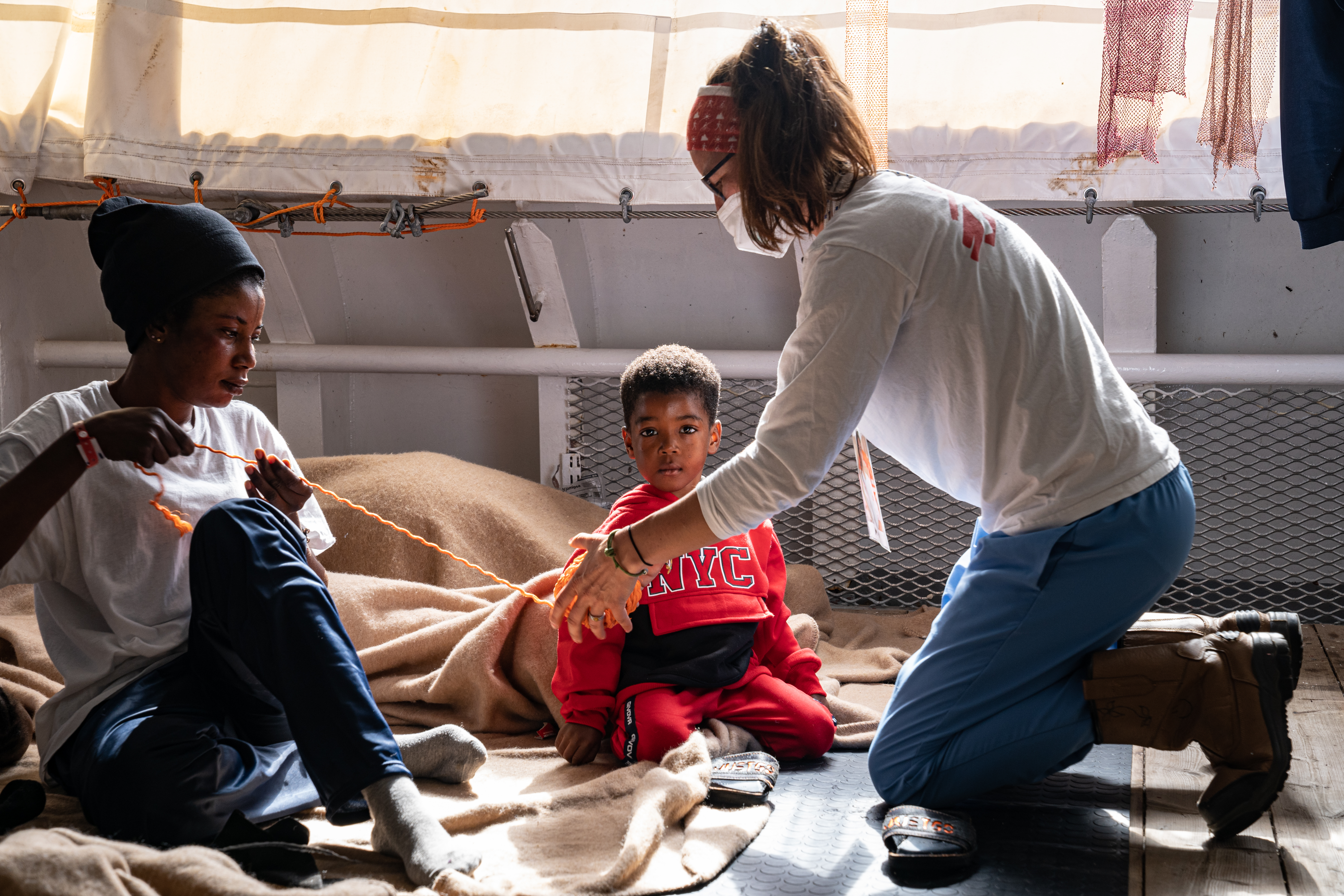 rope found in the search and rescue equipment locker, for her children to play with. Her youngest son, centre, looks directly at the camera. 