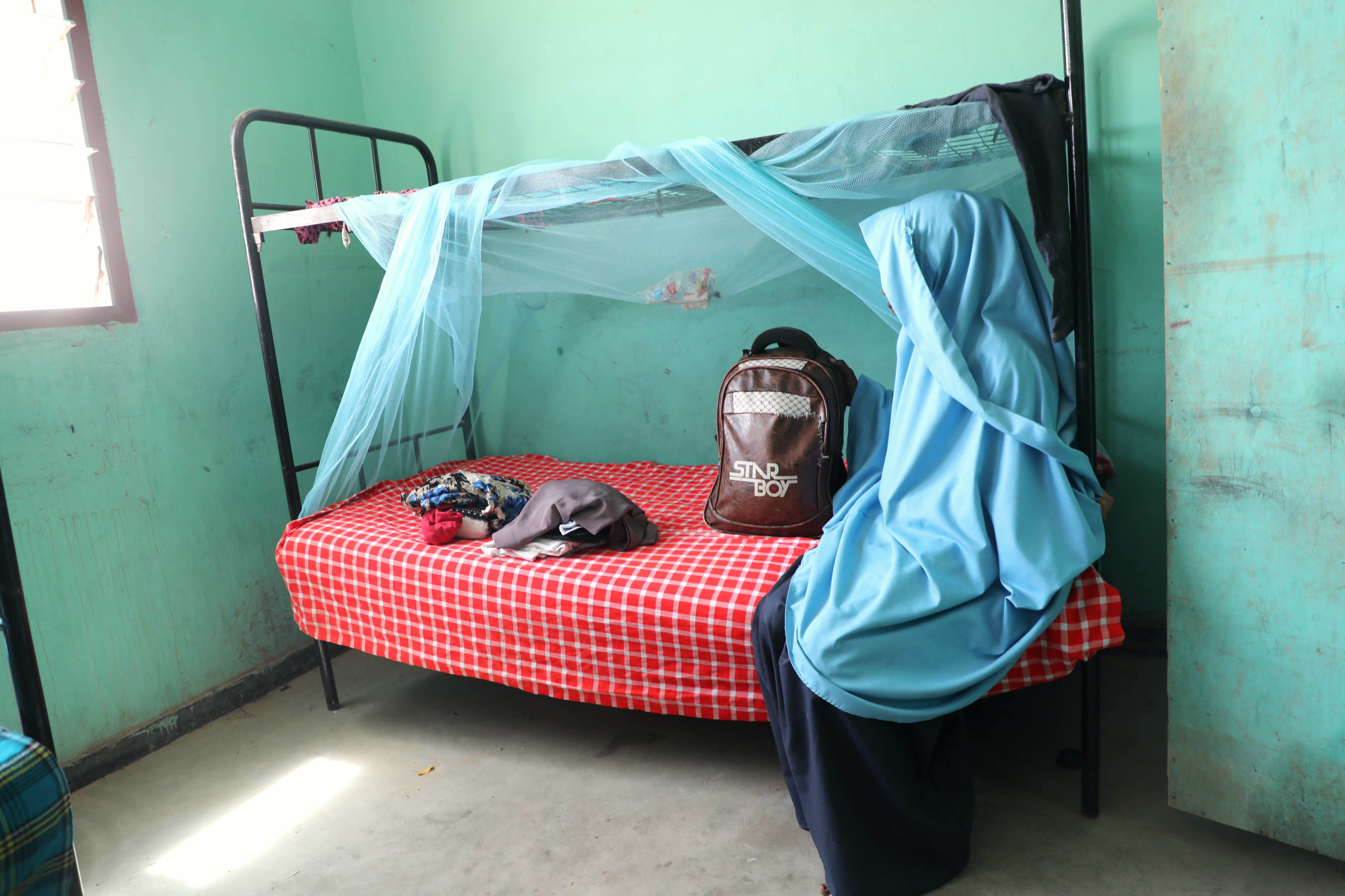 Amira with her belongings that she was rescued with at a Children’s centre.