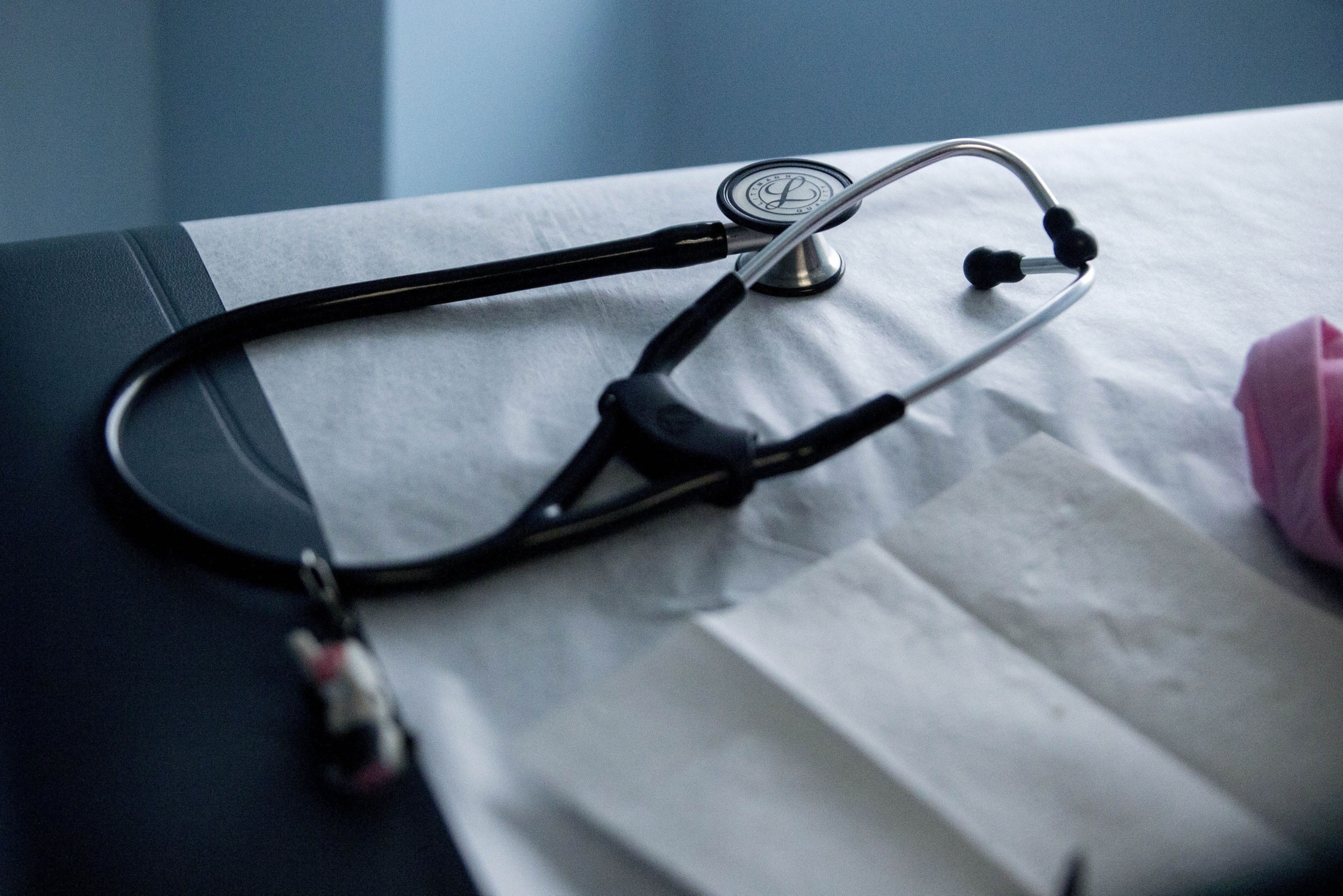 A stethoscope sits on an examination table