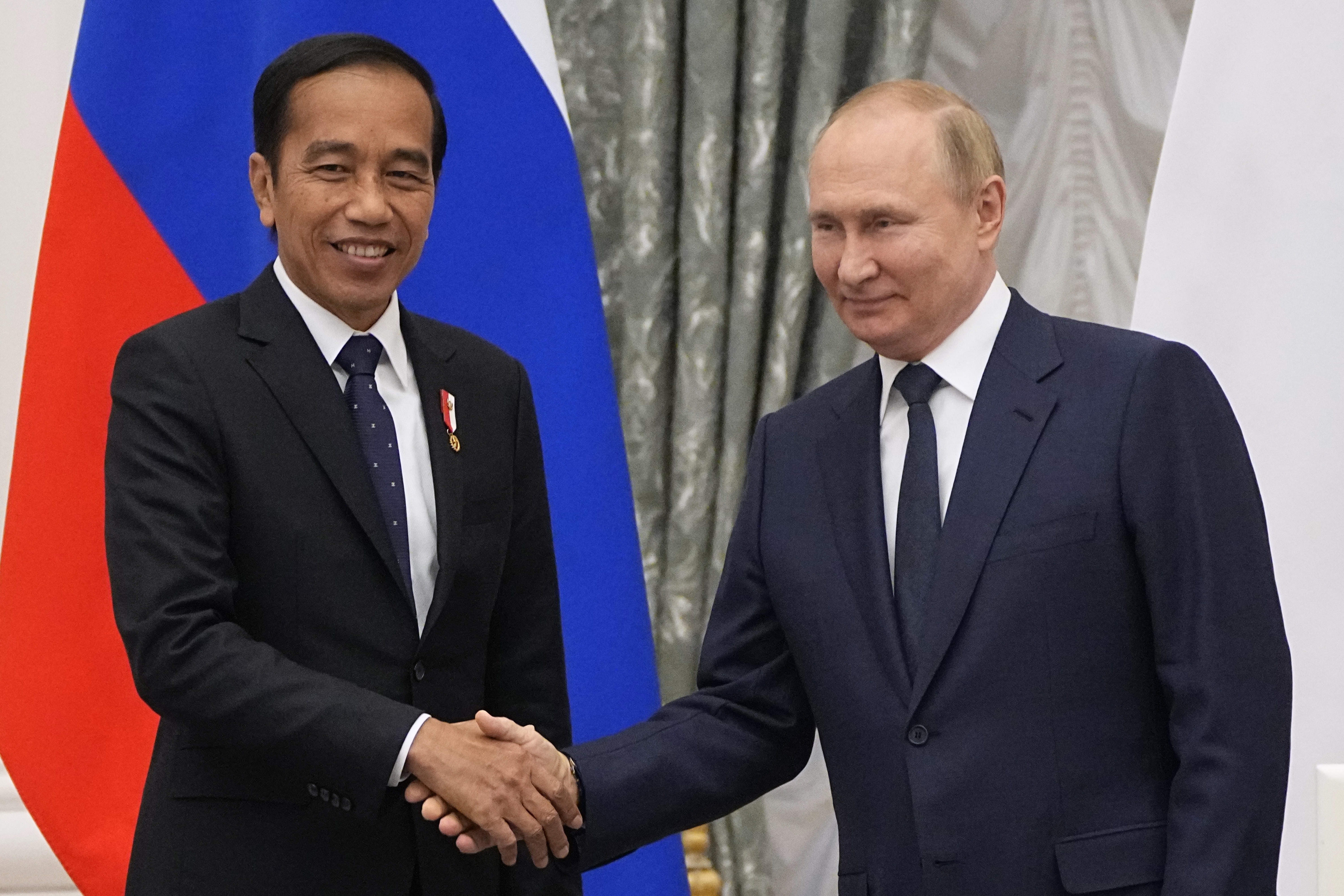 Russian President Vladimir Putin, right, and Indonesian President Joko Widodo shake hands after a joint news conference after their meeting in the Kremlin in Moscow, Russia