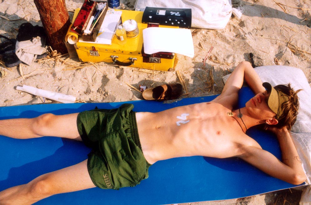 a young artist making temporary tattoos takes a nap between customers.