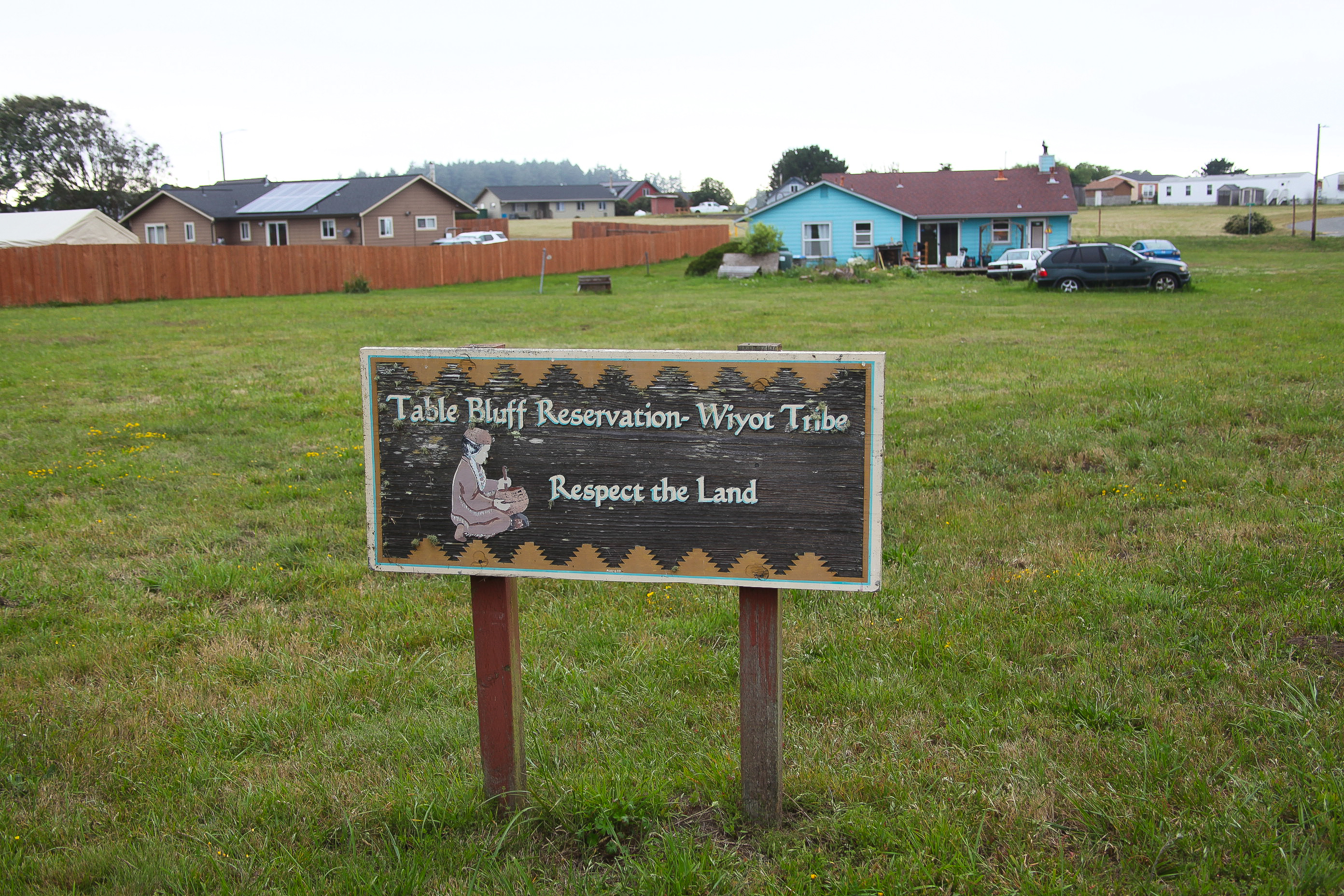 A photo of a sign on a grass lawn that says "Table Bluff Reservation- Wiyot Tribe, Respect the Land".