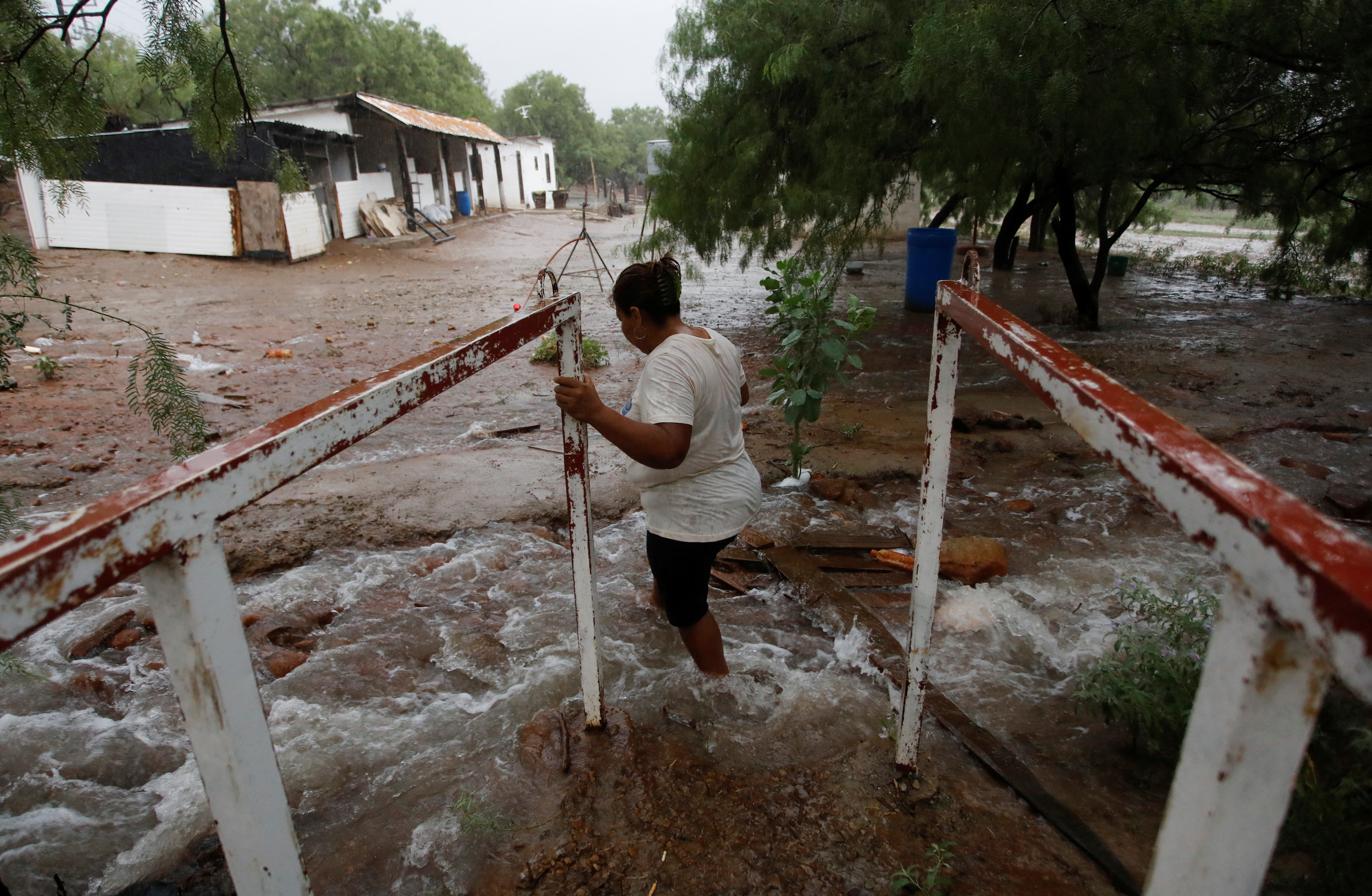 A woman stands near flooding in Mexico