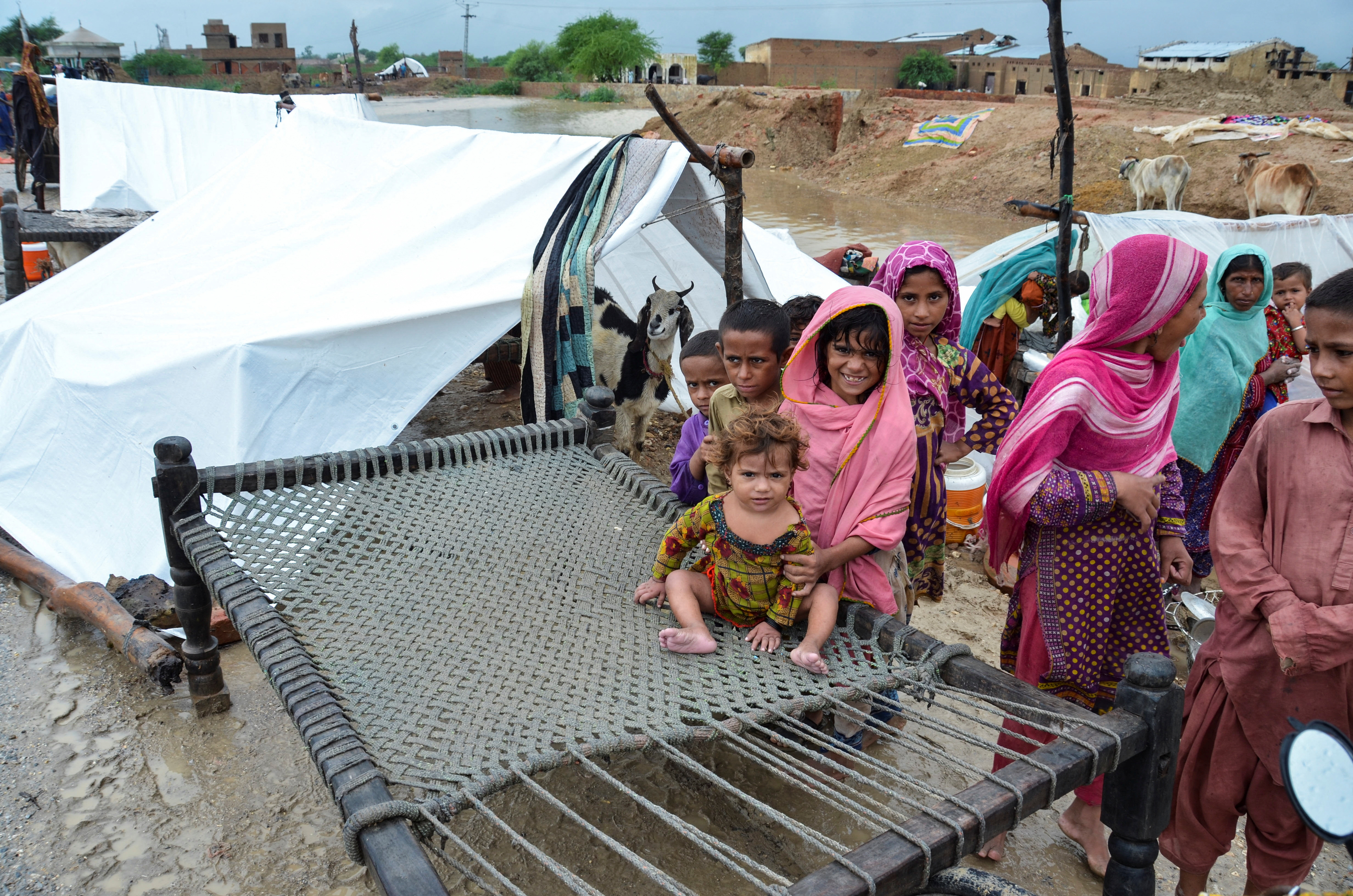 A family takes refuge on a higher ground following rains and floods