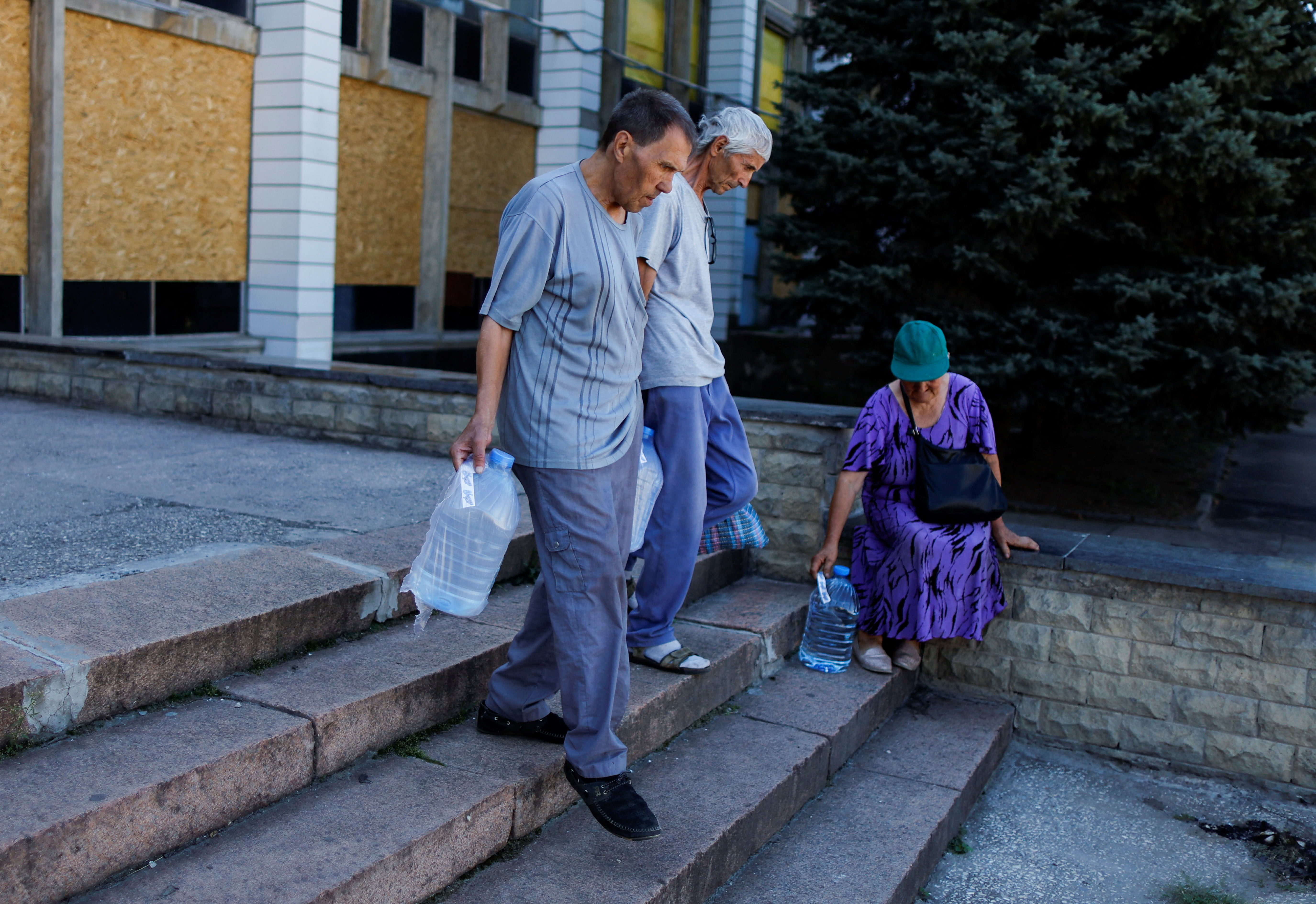 People return to their homes after receiving drinking water organized by the municiipality, amid Russia's invasion, in Kostyantynivka, Ukraine, August 29,2022. REUTERS/Ammar Awad