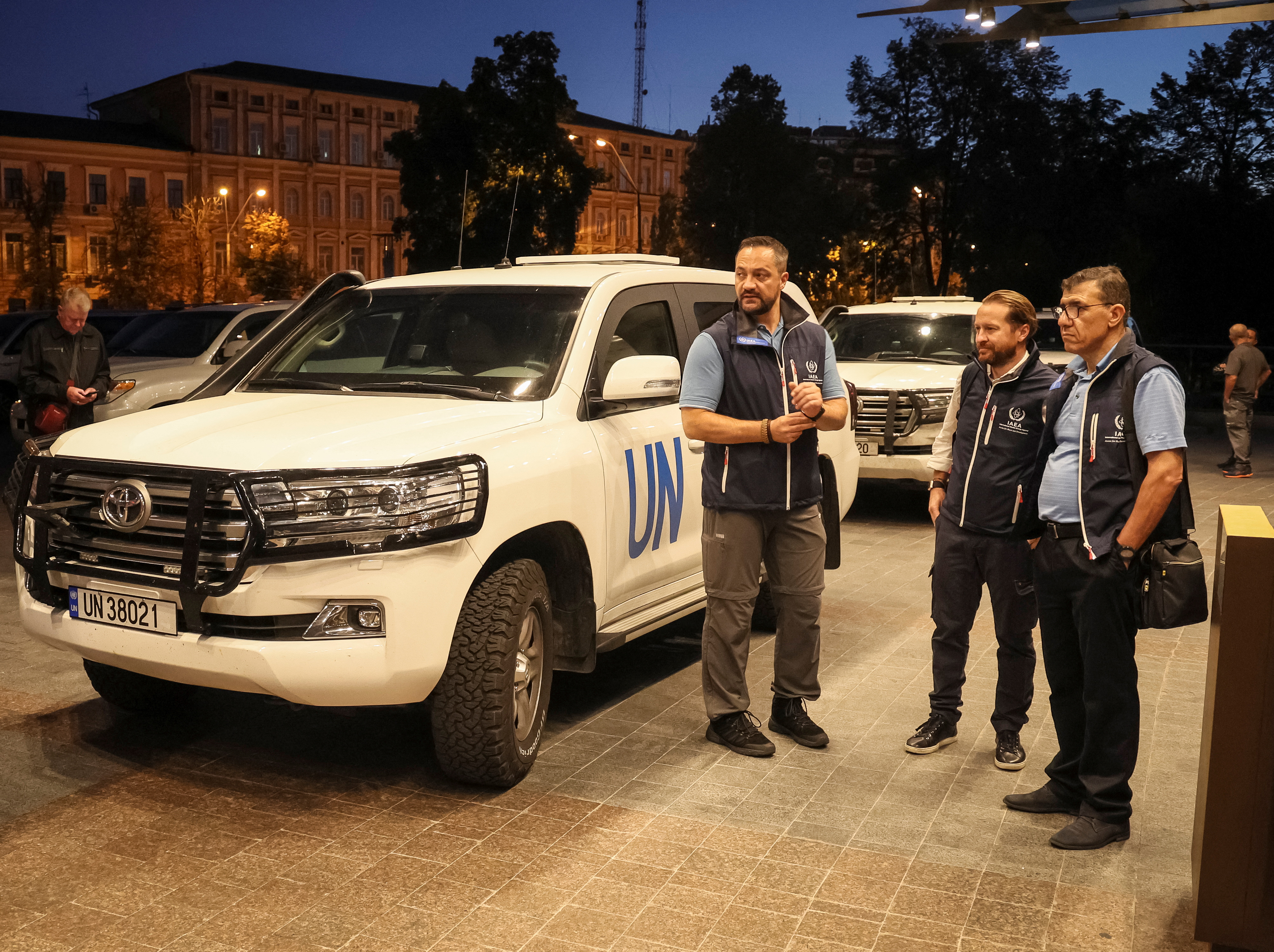 Members of International Atomic Energy Agency (IAEA) mission stand by UN vehicles at hotel in Kyiv.
