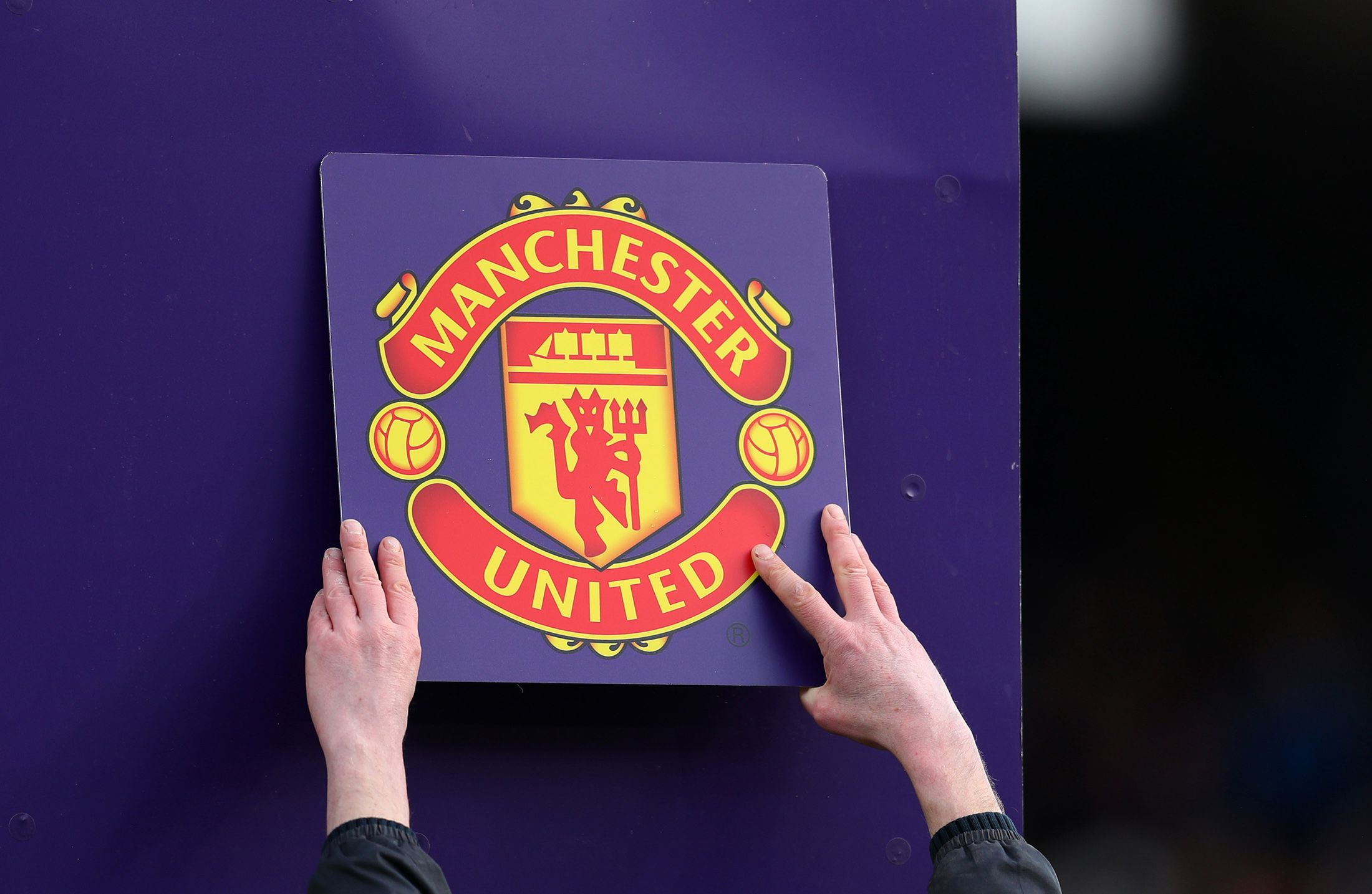 The Manchester United club badge is put up on the board during the Premier League match between Fulham FC and Manchester United at Craven Cottage in London, UK.