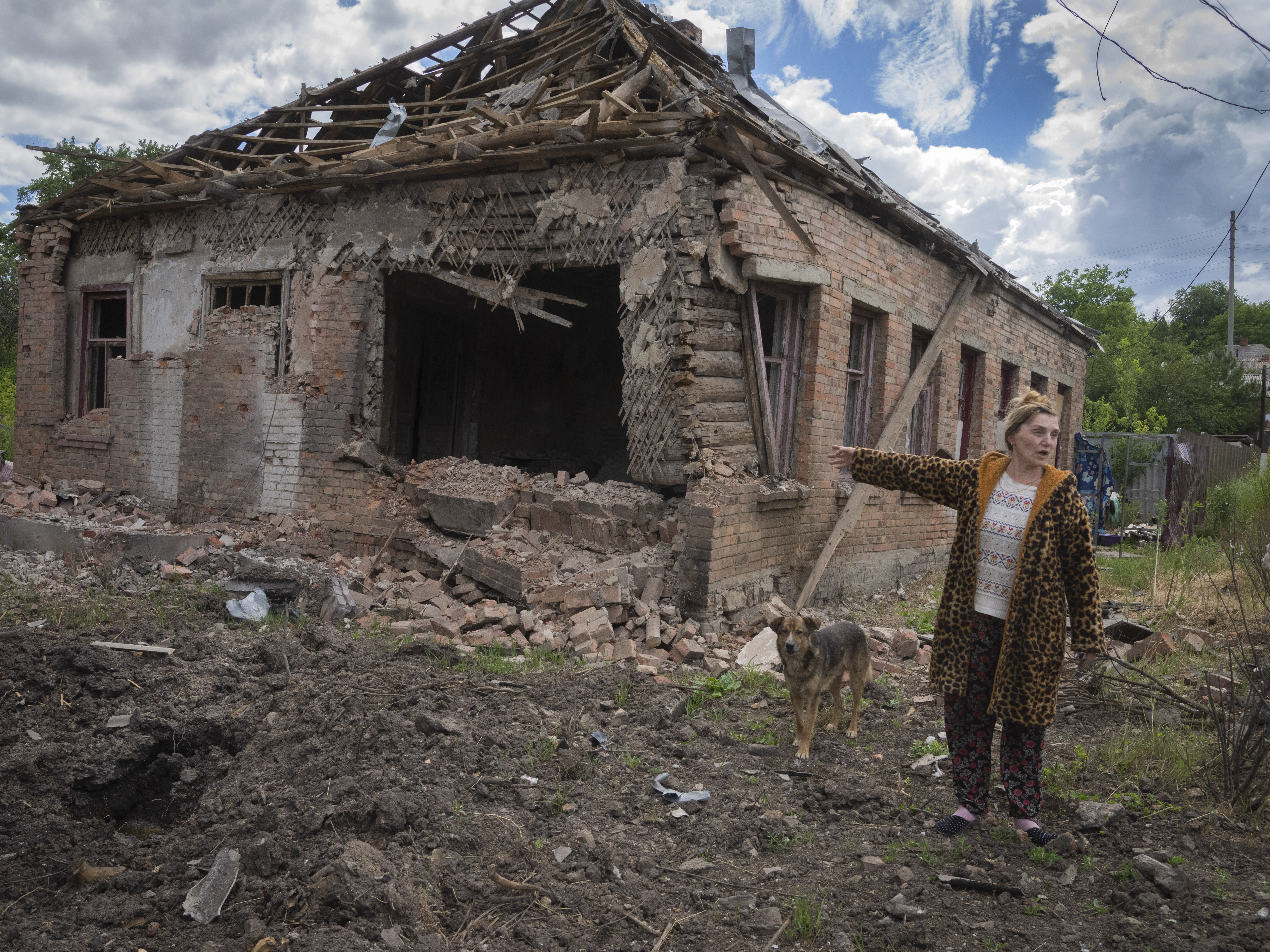 Local resident Tetyana points at her house heavily damaged by the Russian shelling in Bakhmut, Donetsk region, Ukraine